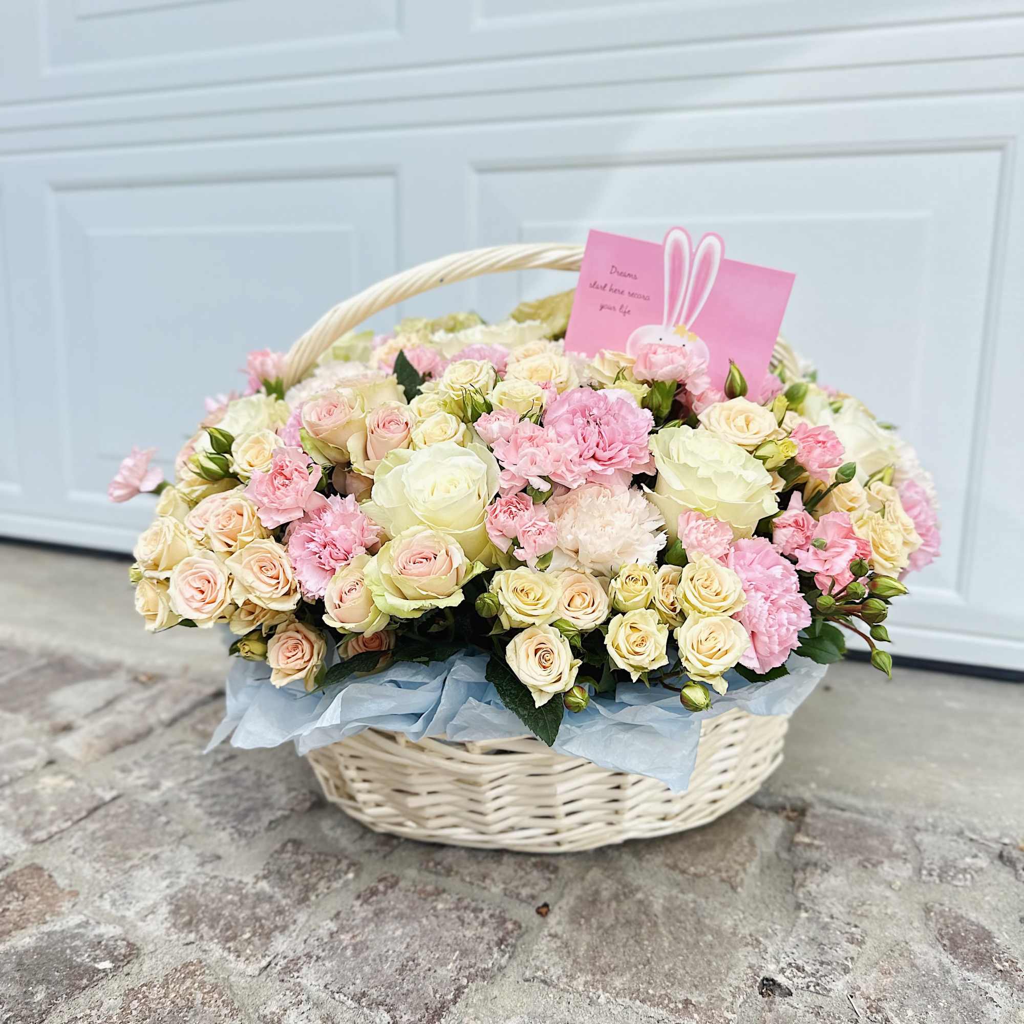 This refined arrangement in a woven basket is filled with the softest