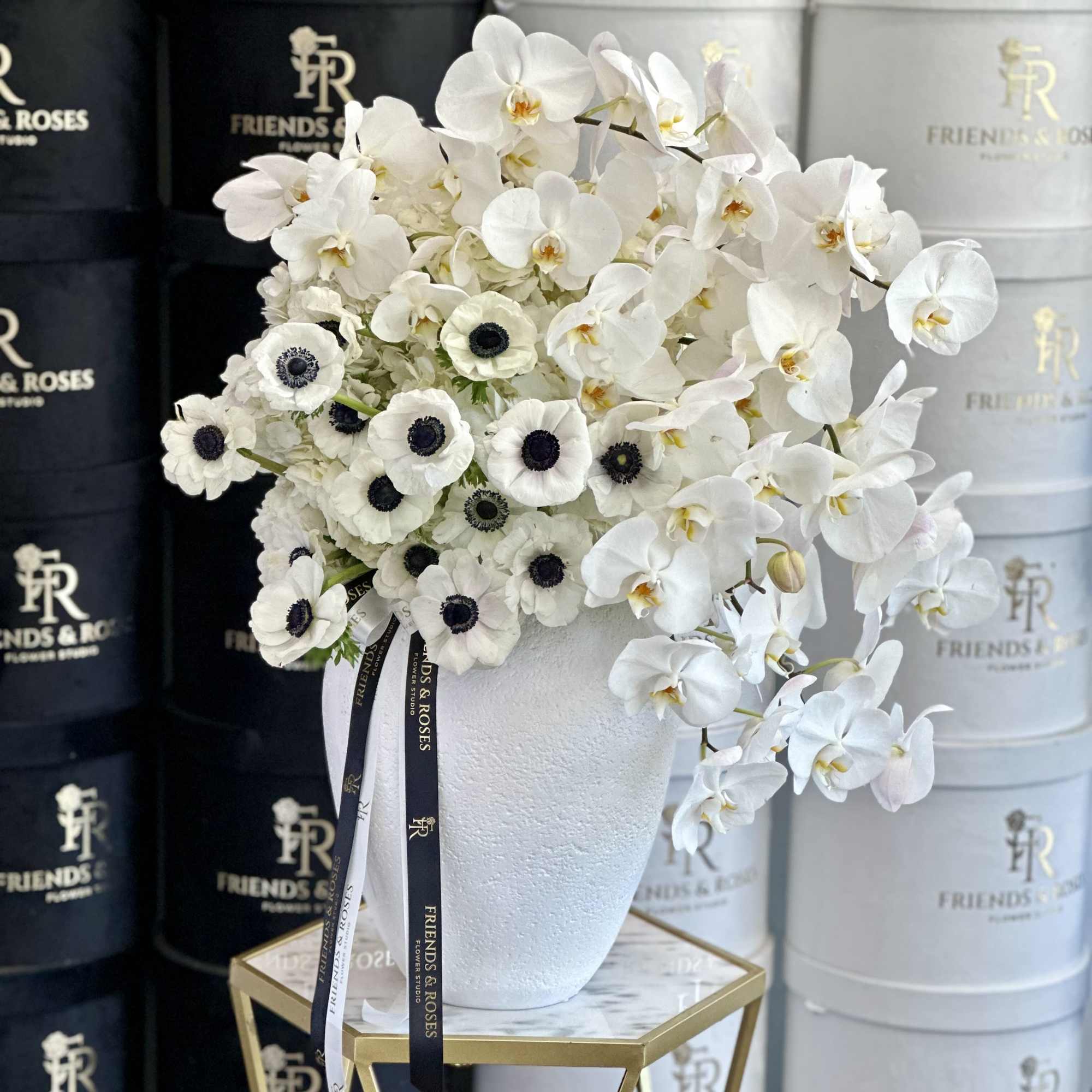 An elegant composition of white orchids and anemones, thoughtfully arranged in a