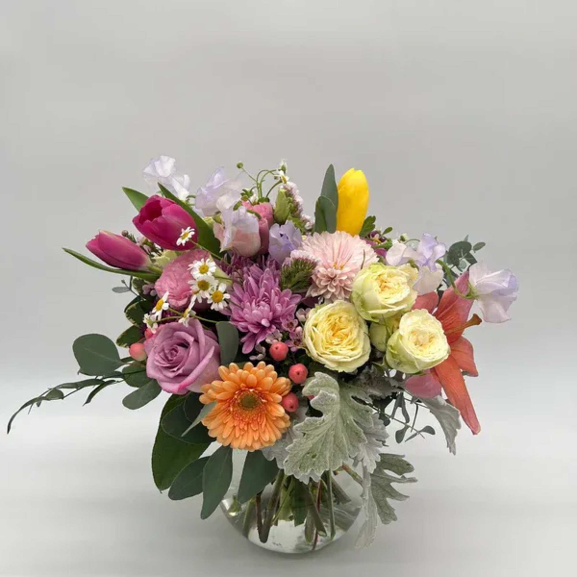Soft pastels and cheerful blooms come together in this whimsical spring arrangement