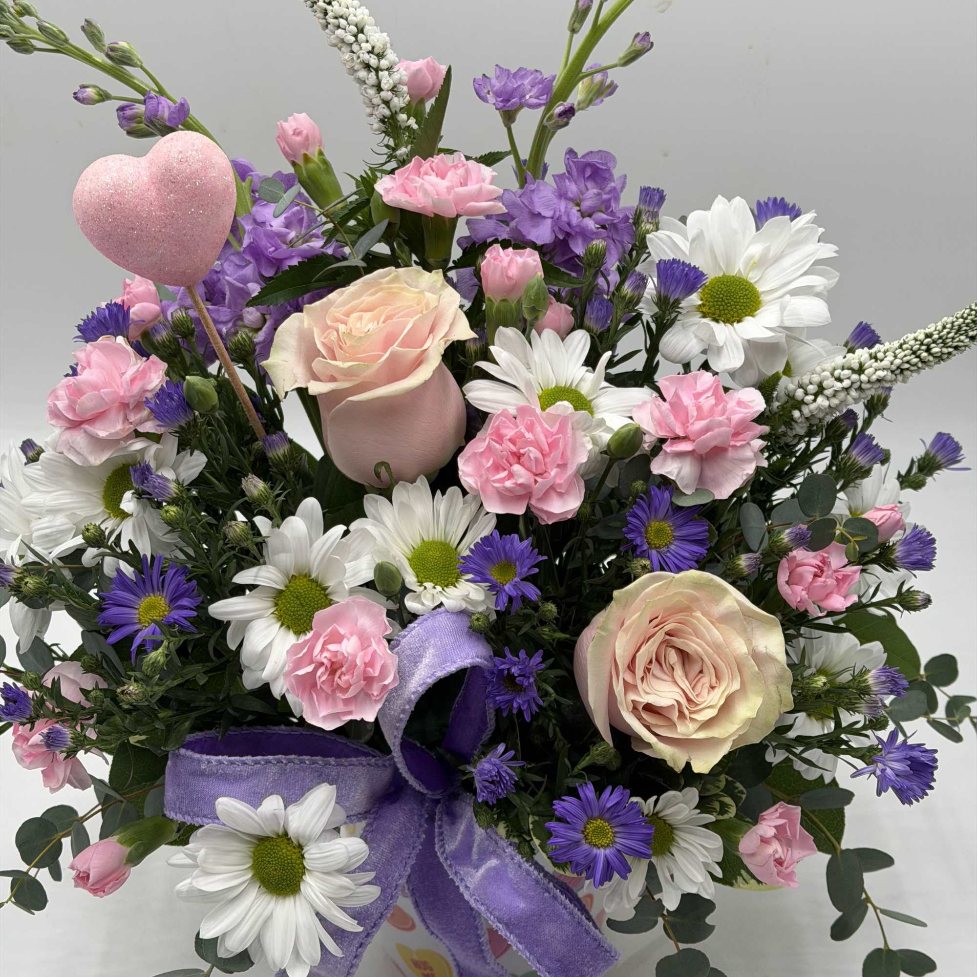 Celebrate love with soft blush roses, sweet pink carnations, white daisies and