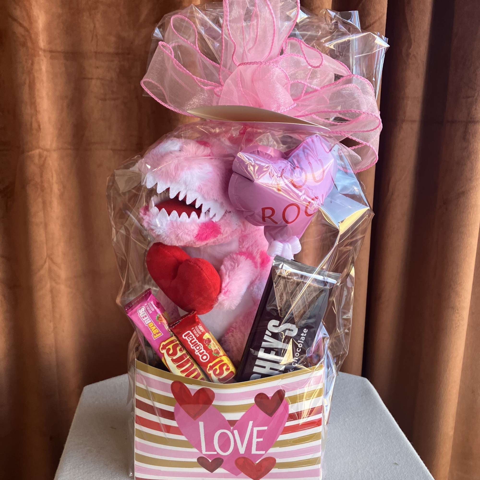 This playful gift box features an adorable plush dinosaur paired with a