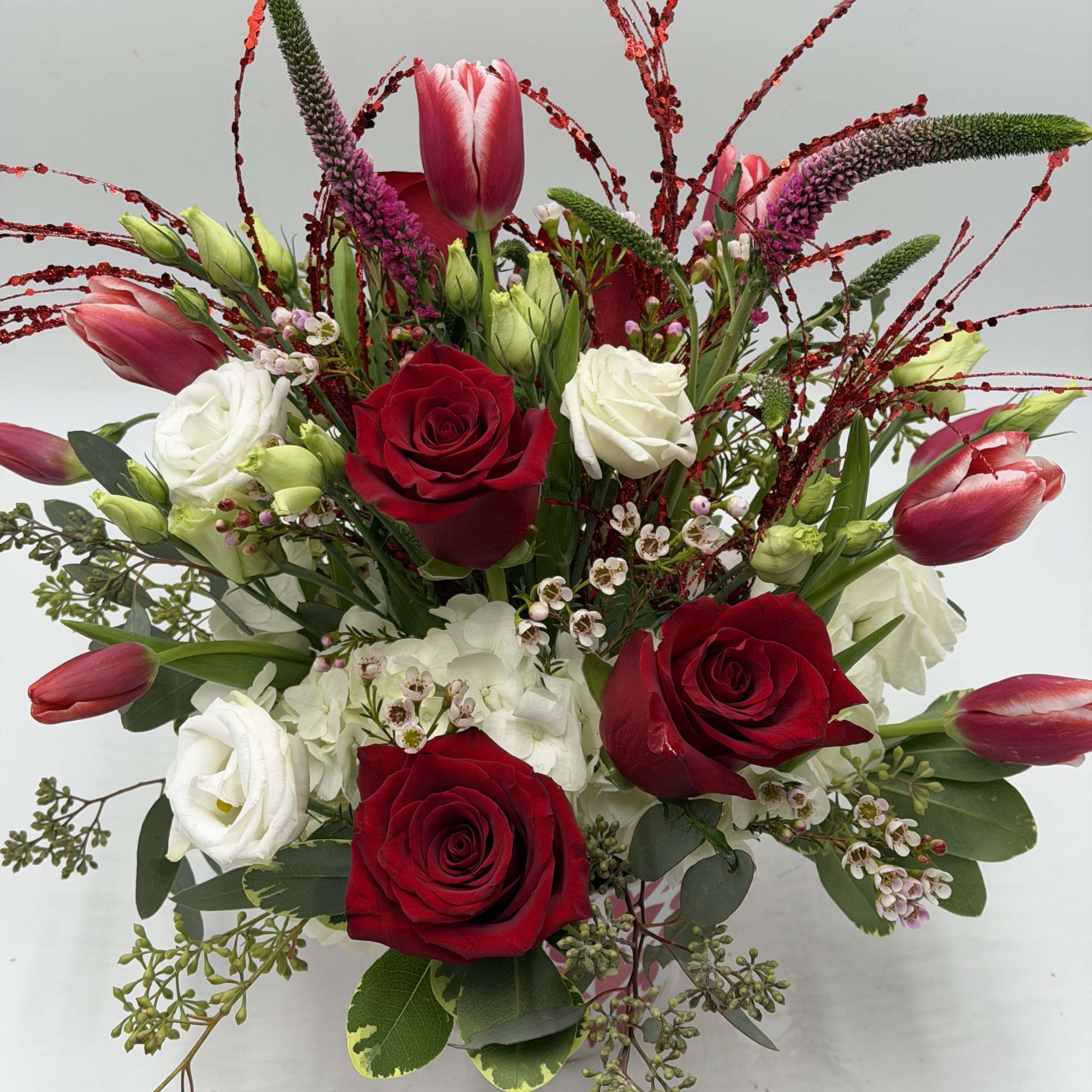 A contemporary take on Valentine's florals, this arrangement features vibrant red roses