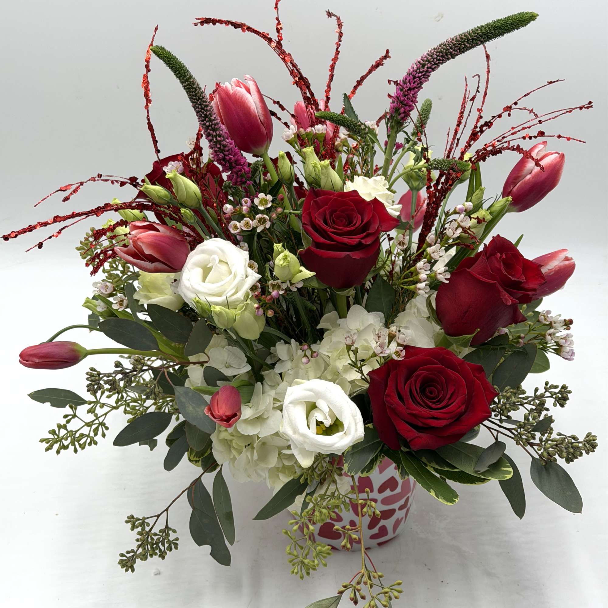 A contemporary take on Valentine's florals, this arrangement features vibrant red roses