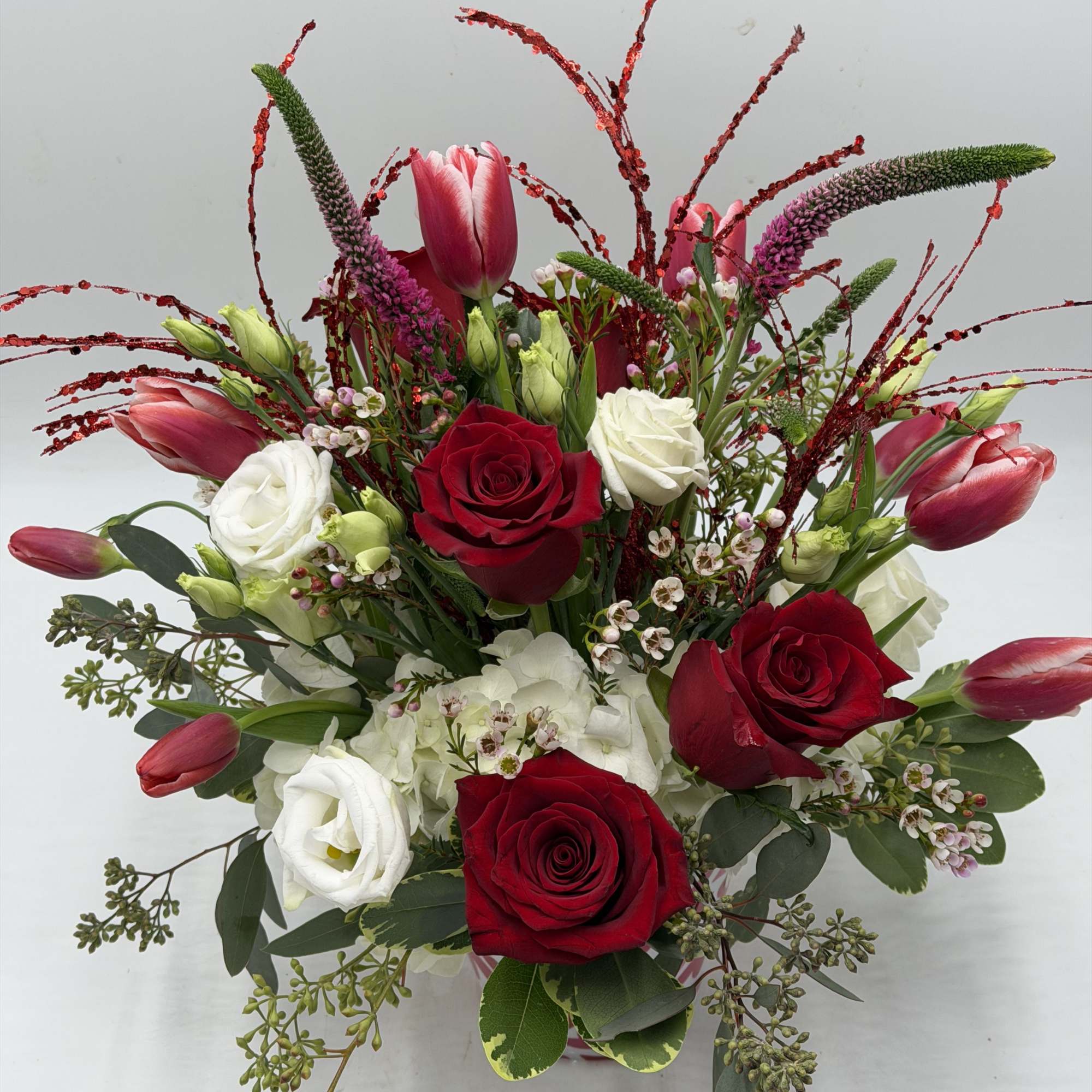 A contemporary take on Valentine's florals, this arrangement features vibrant red roses