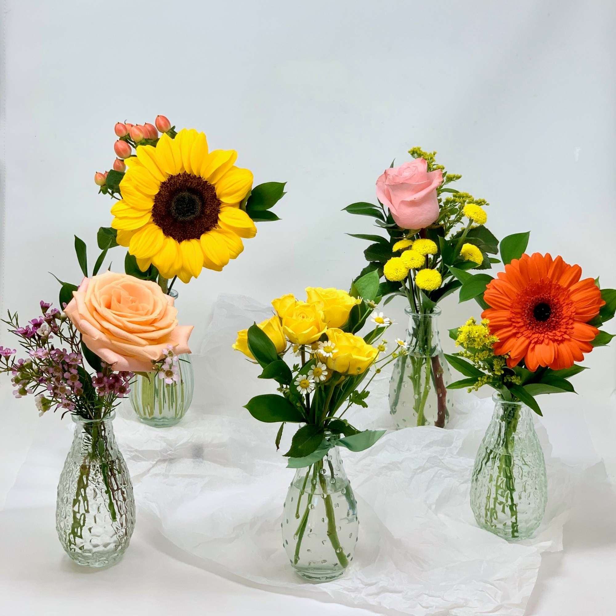 Each bud vase is arranged with one single seasonal flower, the thriller