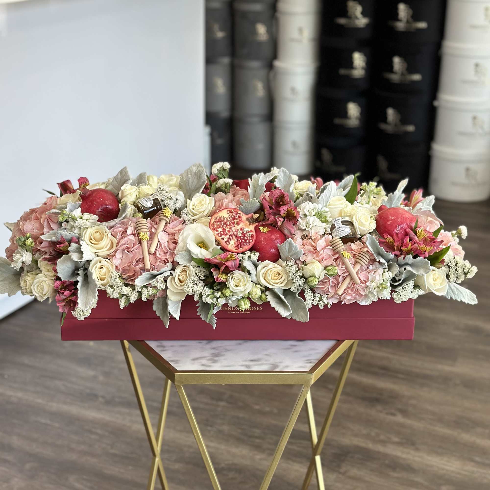 Festive floral box filled with seasonal blooms, fresh pomegranates, and sweet honey