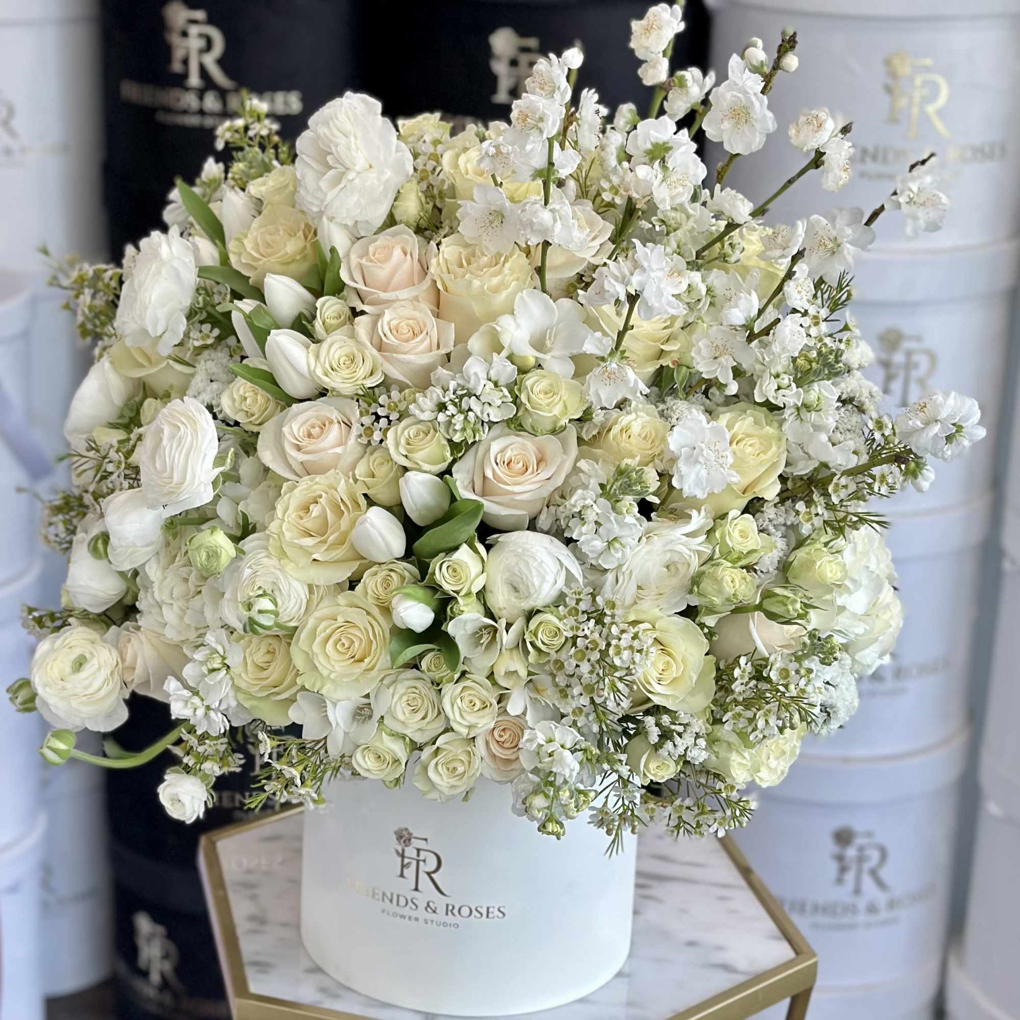 The box contains a meticulously arranged selection of premium white flowers, each