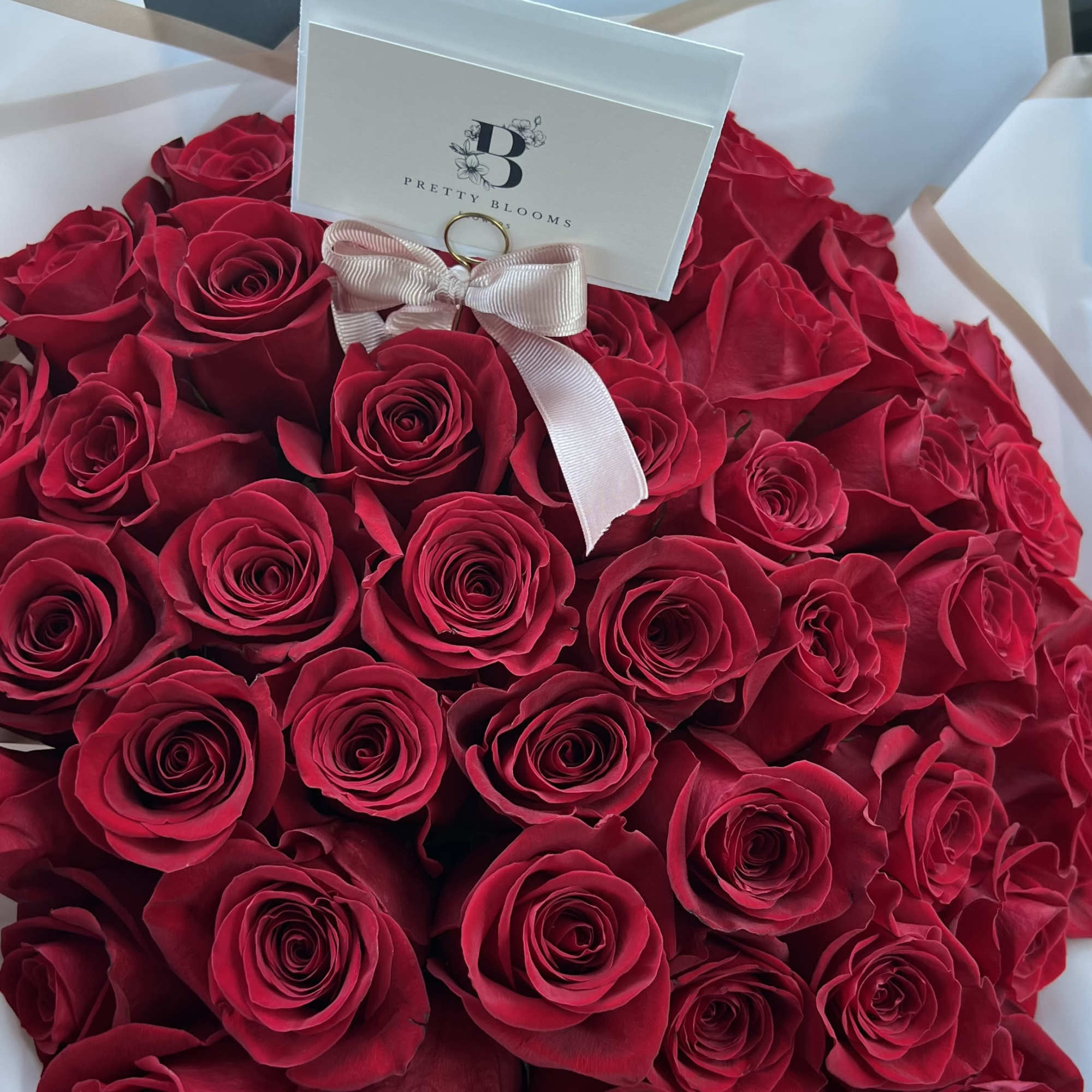 A Stunning wrapped bouquet of 50 long stem premium red roses. Perfect