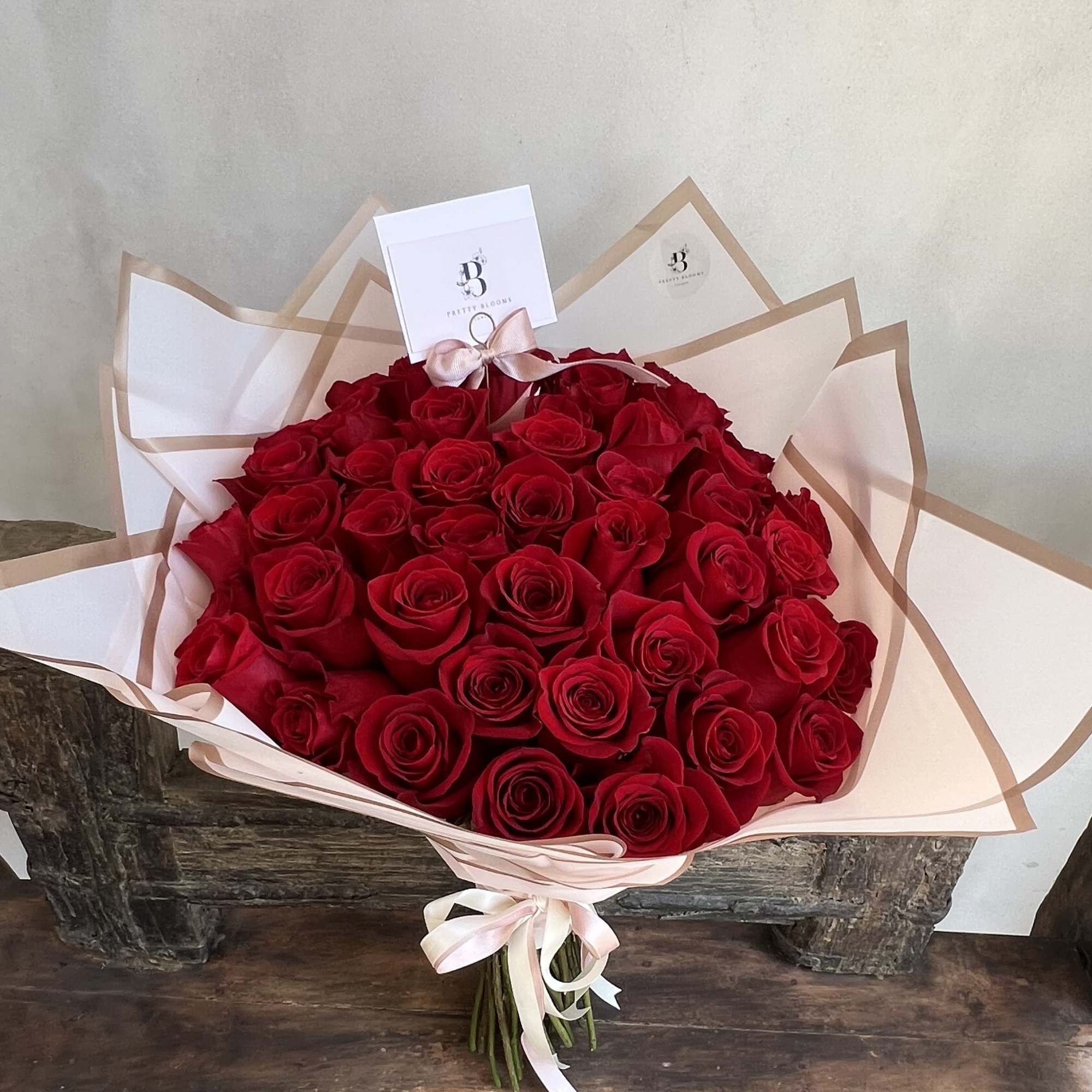 A Stunning wrapped bouquet of 50 long stem premium red roses. Perfect