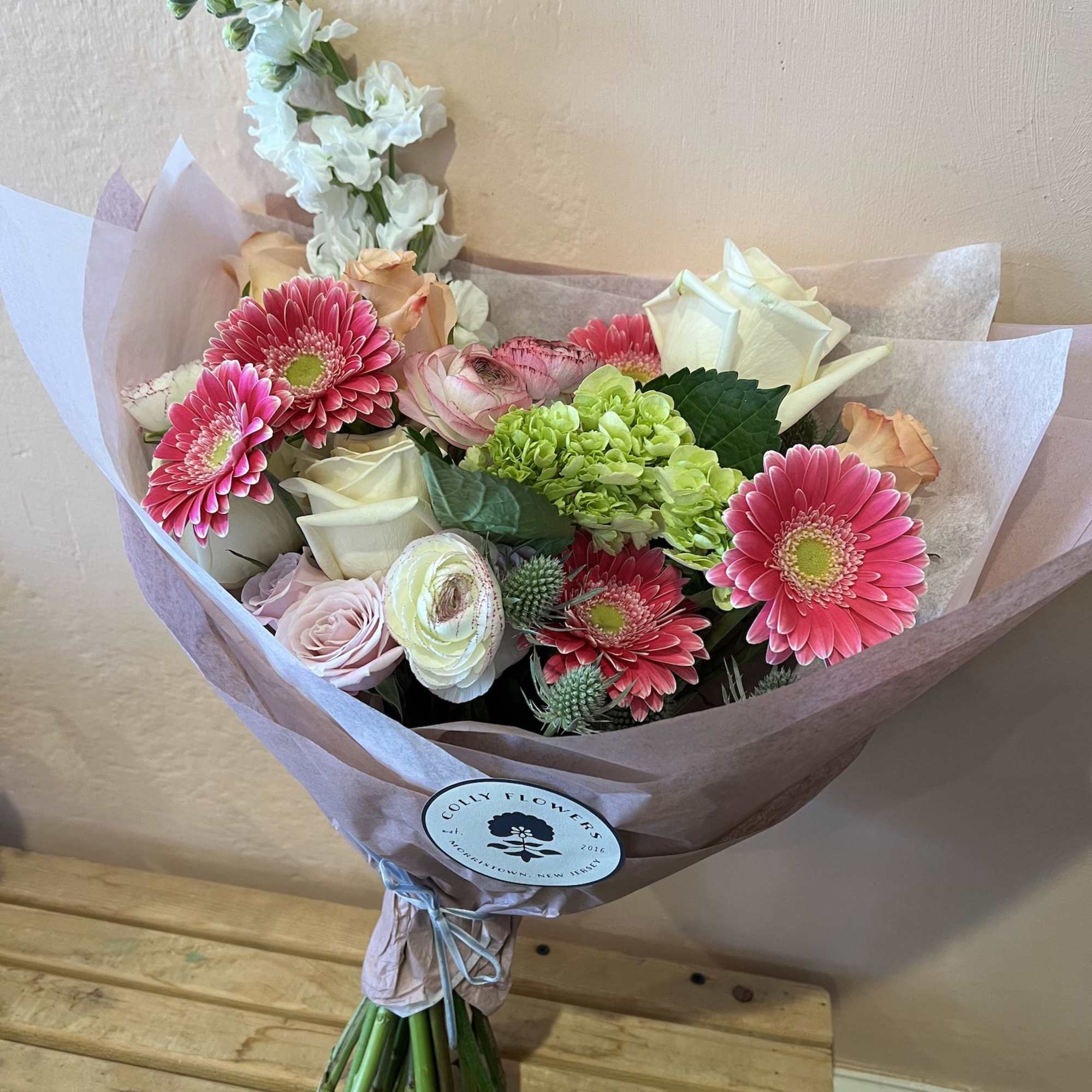 Seasonal, colorful flowers and foliage artfully arranged, wrapped in tissue and ready