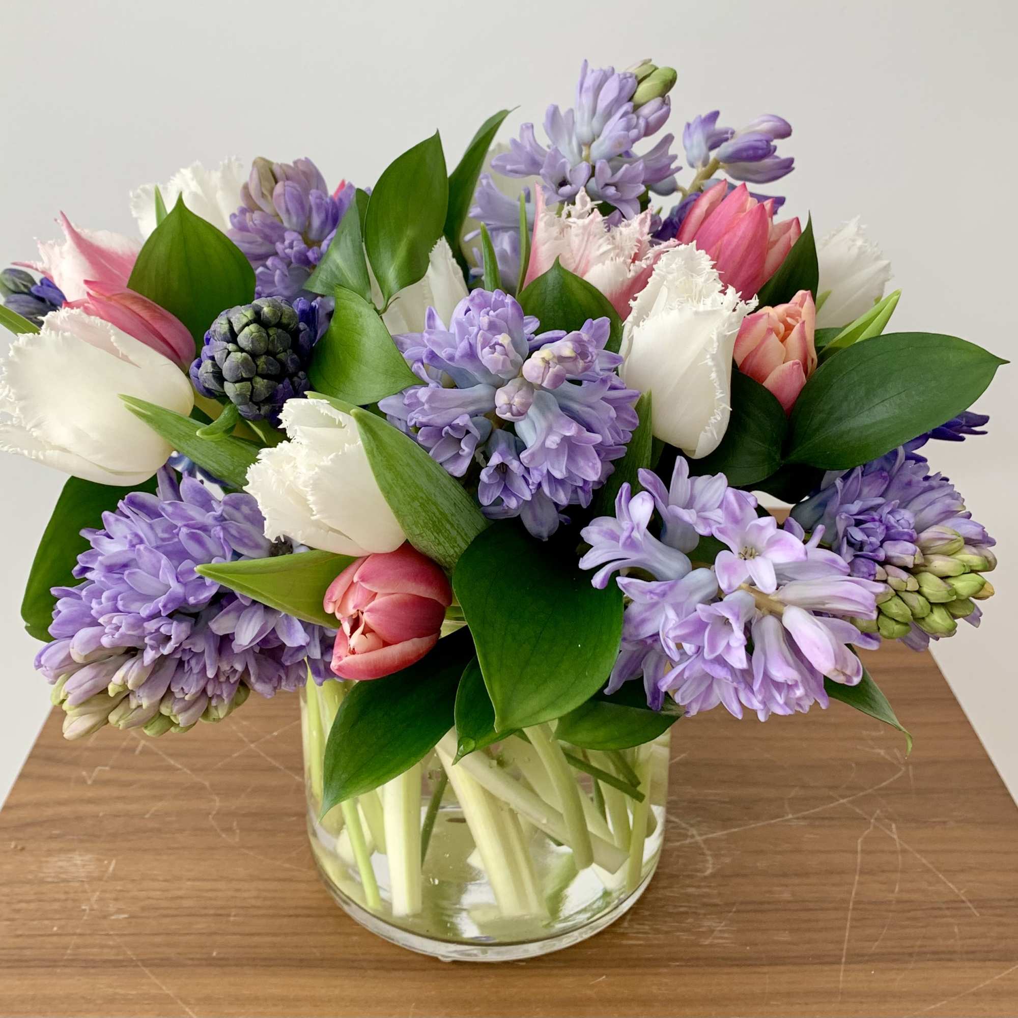 A simple elegant flower arrangement of fragrant hyacinths and tulips, with greenery