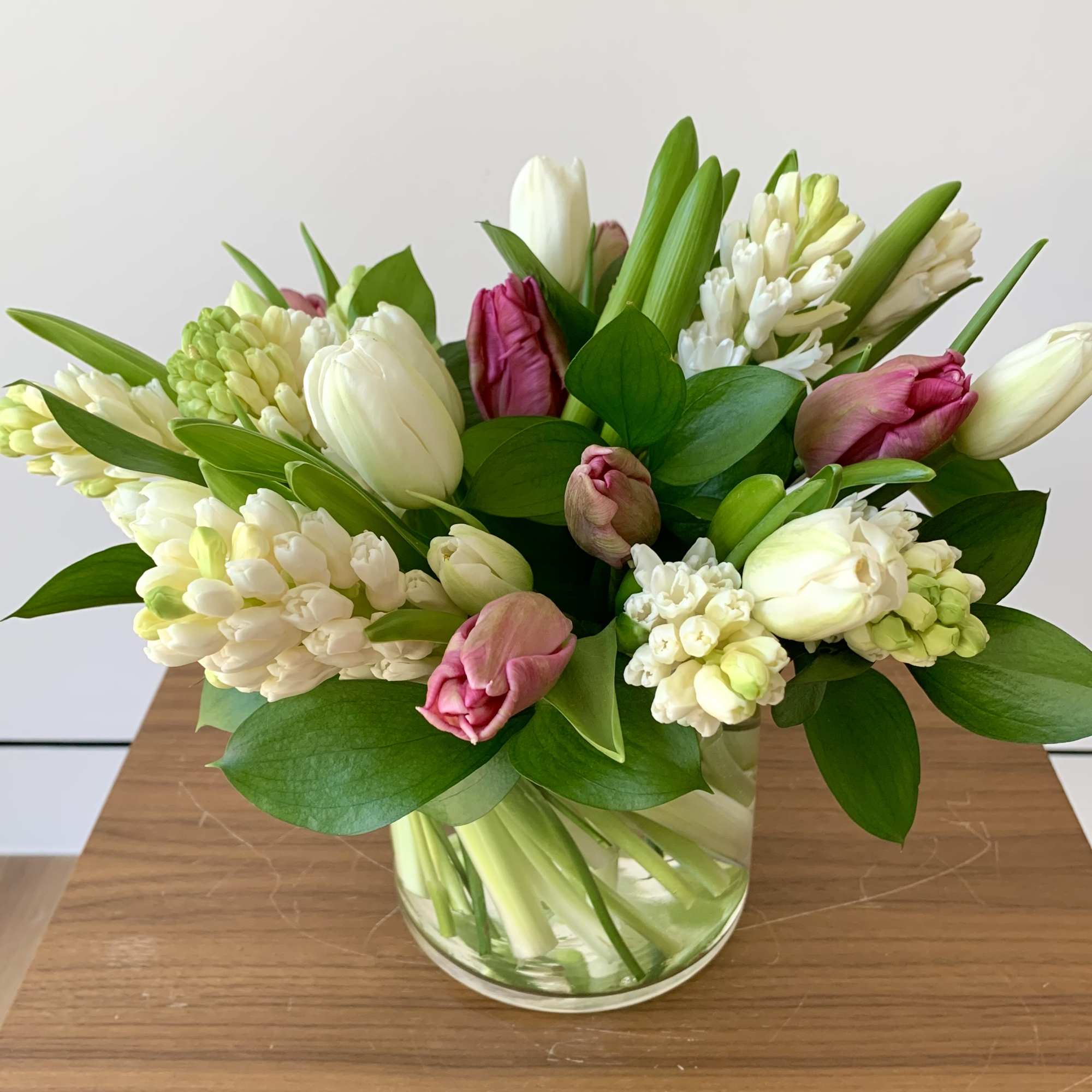 A simple elegant flower arrangement of fragrant hyacinths and tulips, with greenery