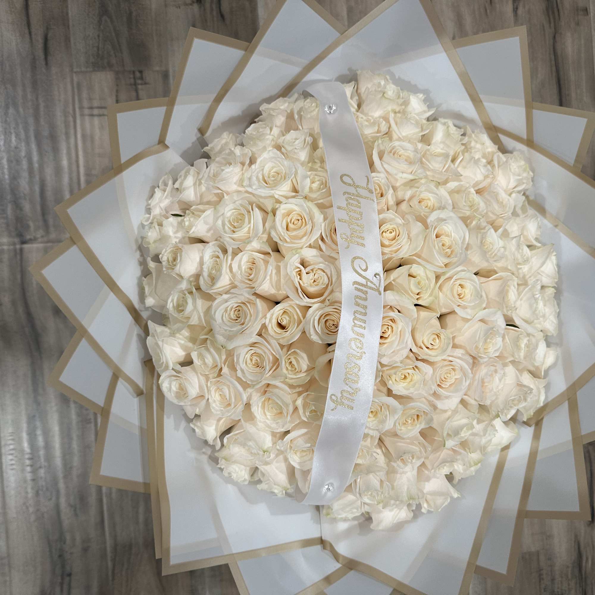 Standard: 100 White Roses, Choice of Color wrapping Paper

Deluxe: 100 White Roses