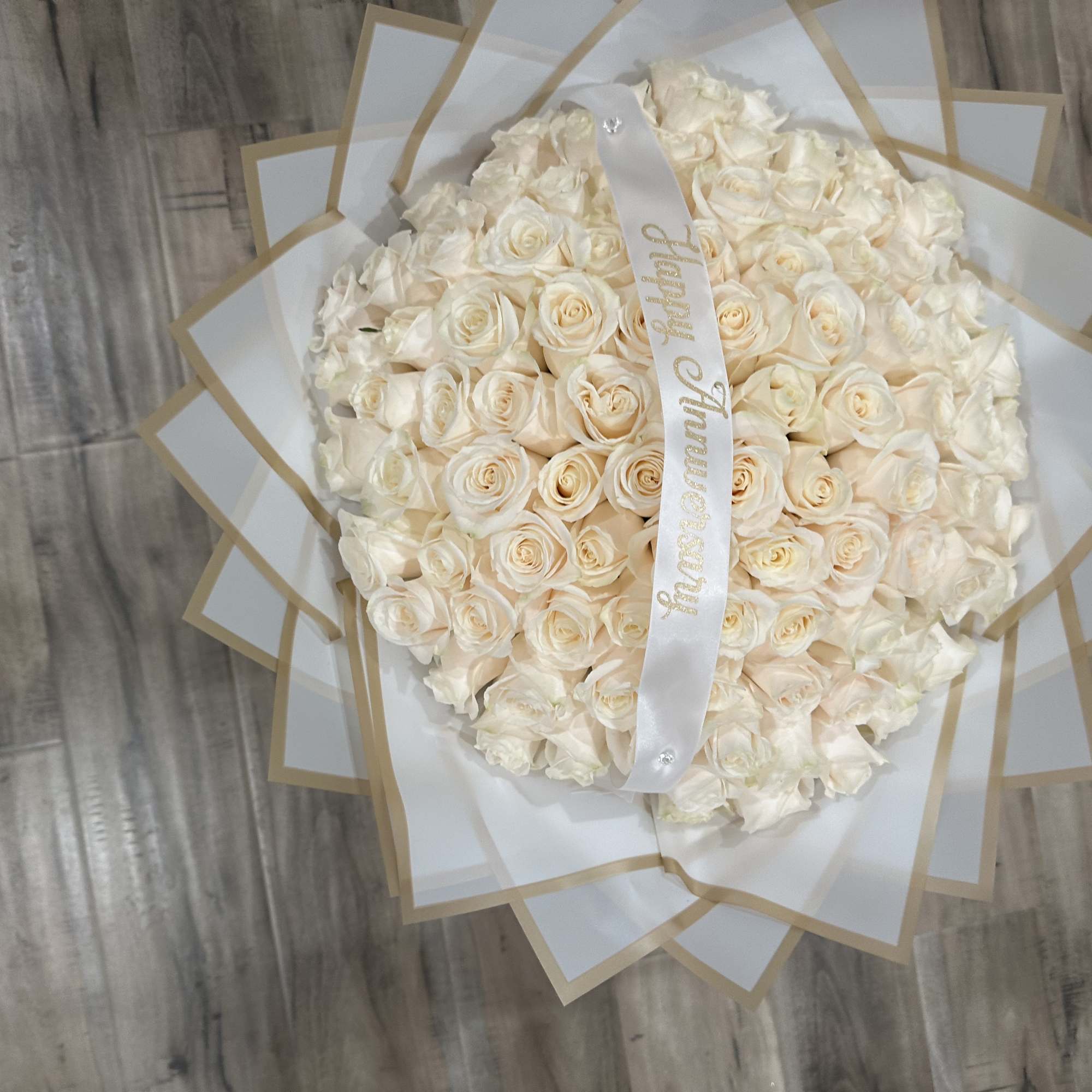 Standard: 100 White Roses, Choice of Color wrapping Paper

Deluxe: 100 White Roses