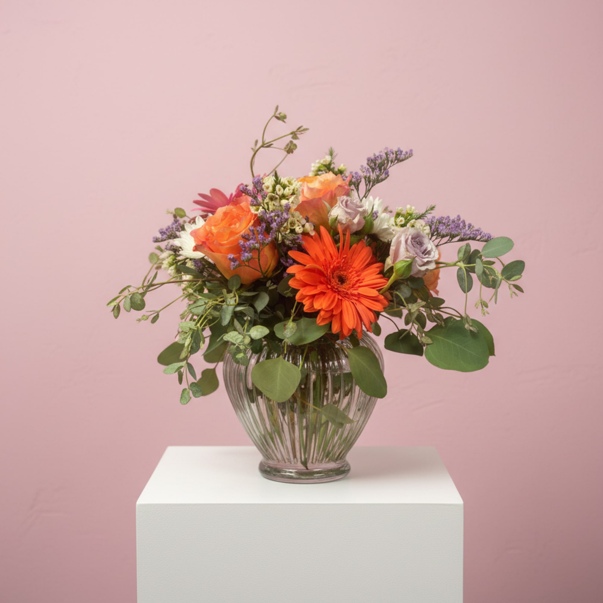 Stunning roses, Gerbera Daisies and Cushion mums with seasonal filler make a