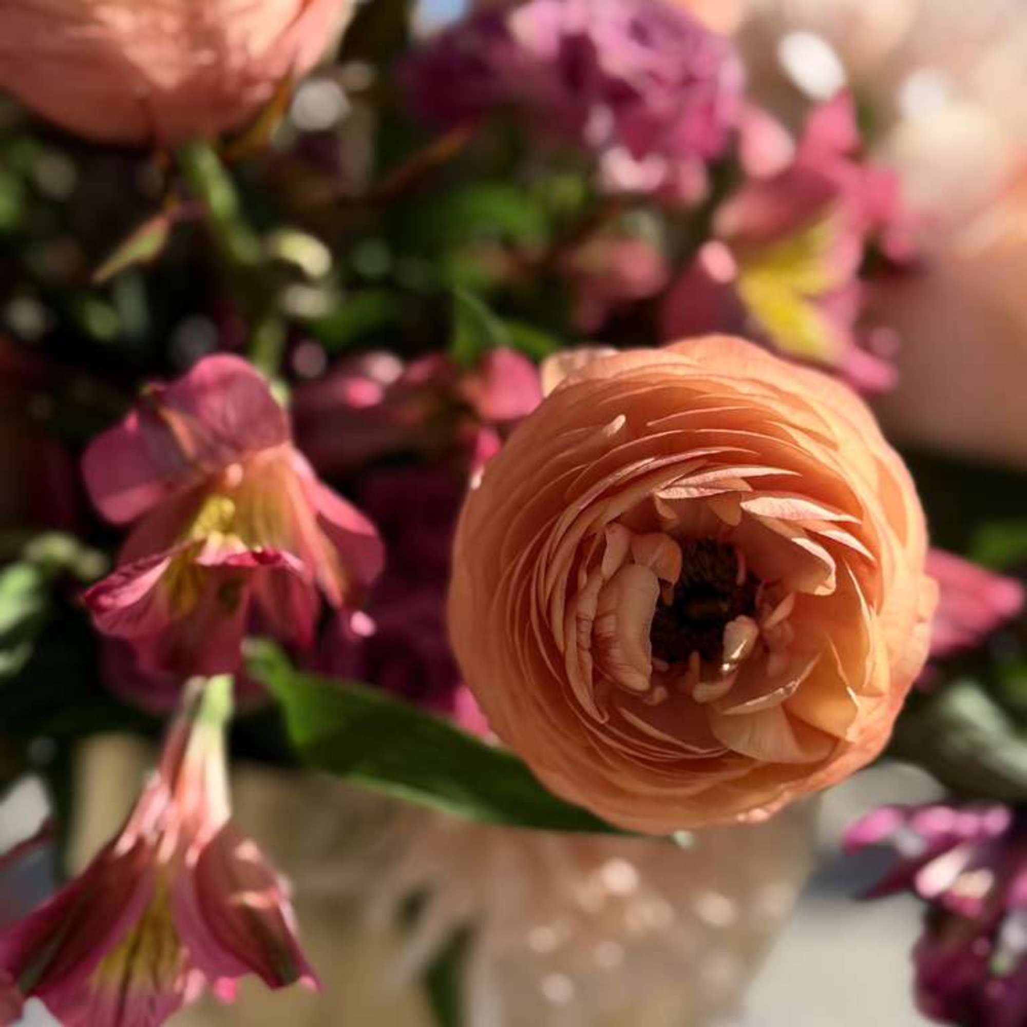 Peach roses and blush florals meet deep magenta accents in this lush