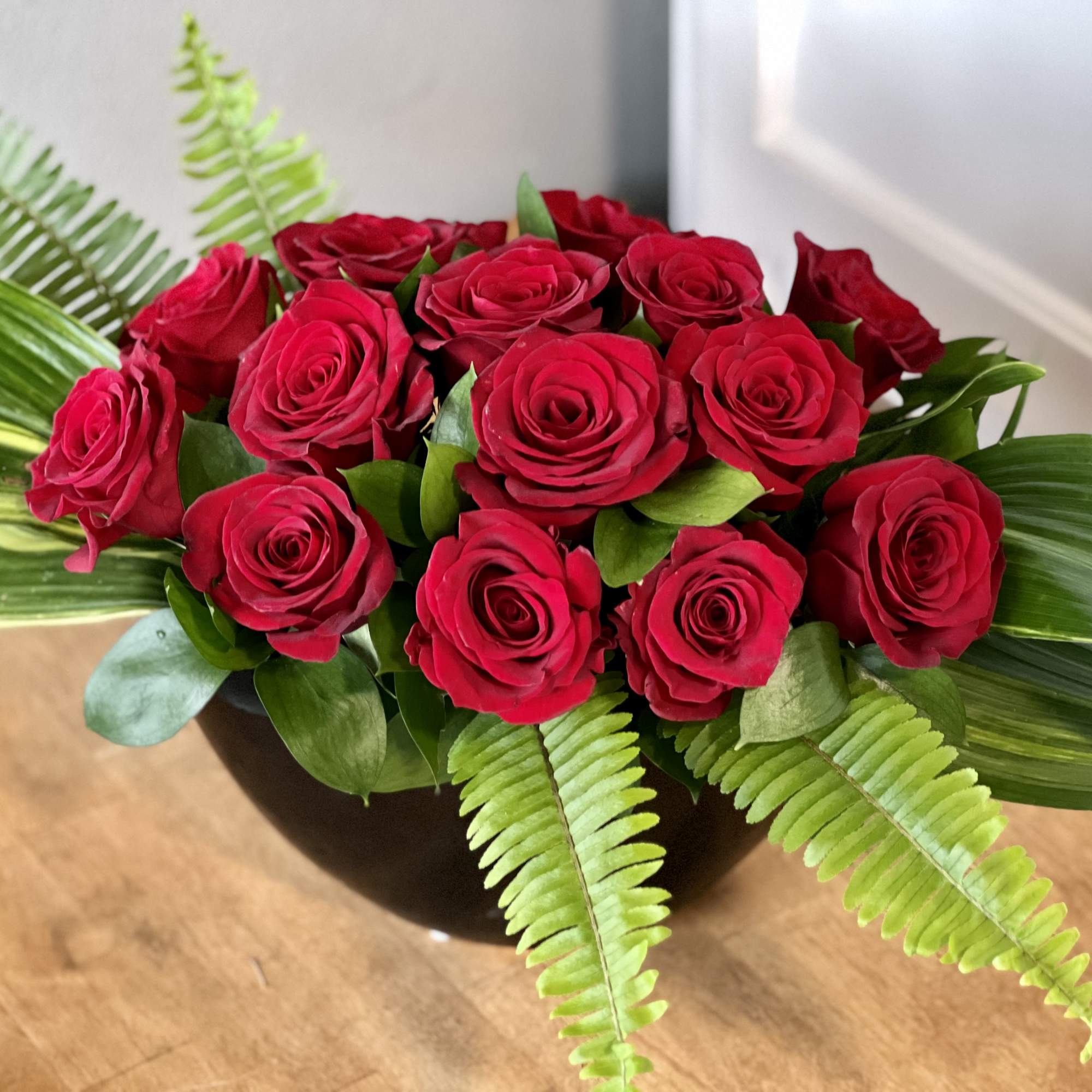 A sleek and elegant modern arrangement of 15 red roses in a