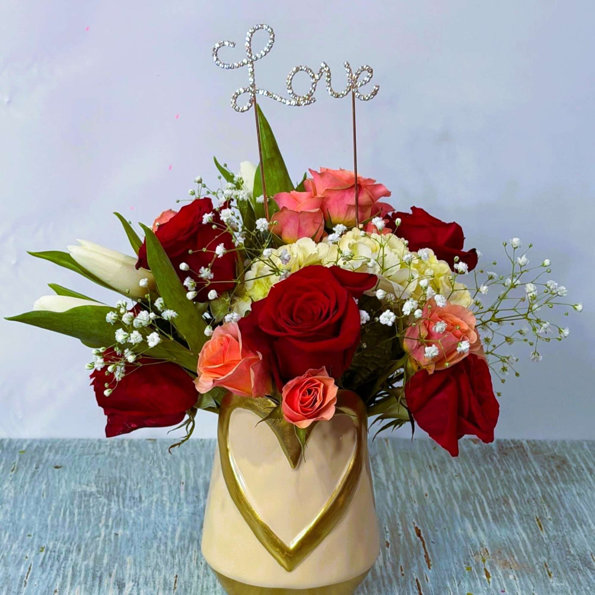 Red, Pink and white arrangement designed in a white, ceramic vase with