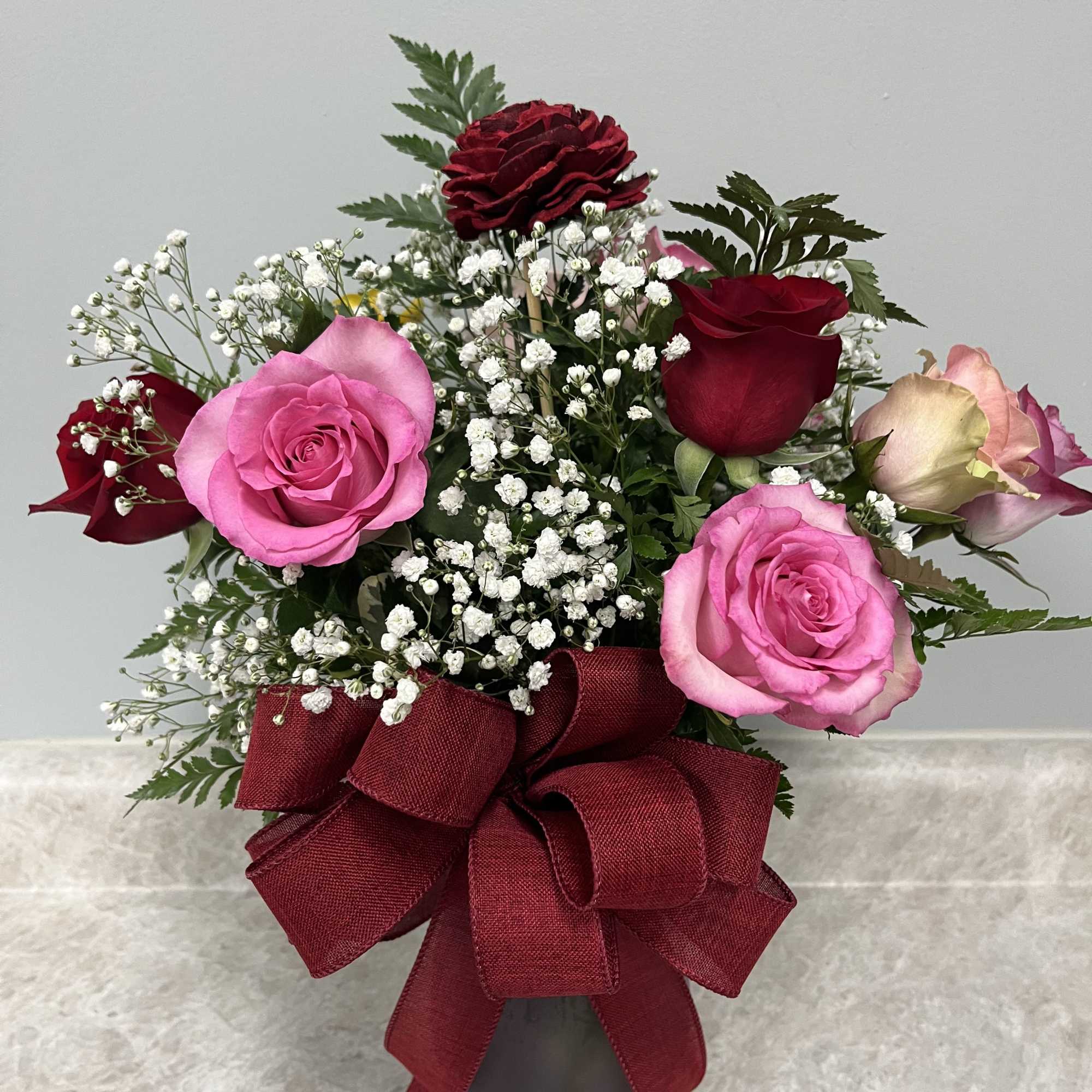 Eleven assorted colored roses with one wooden rose keepsake
all around arrangment 
approx