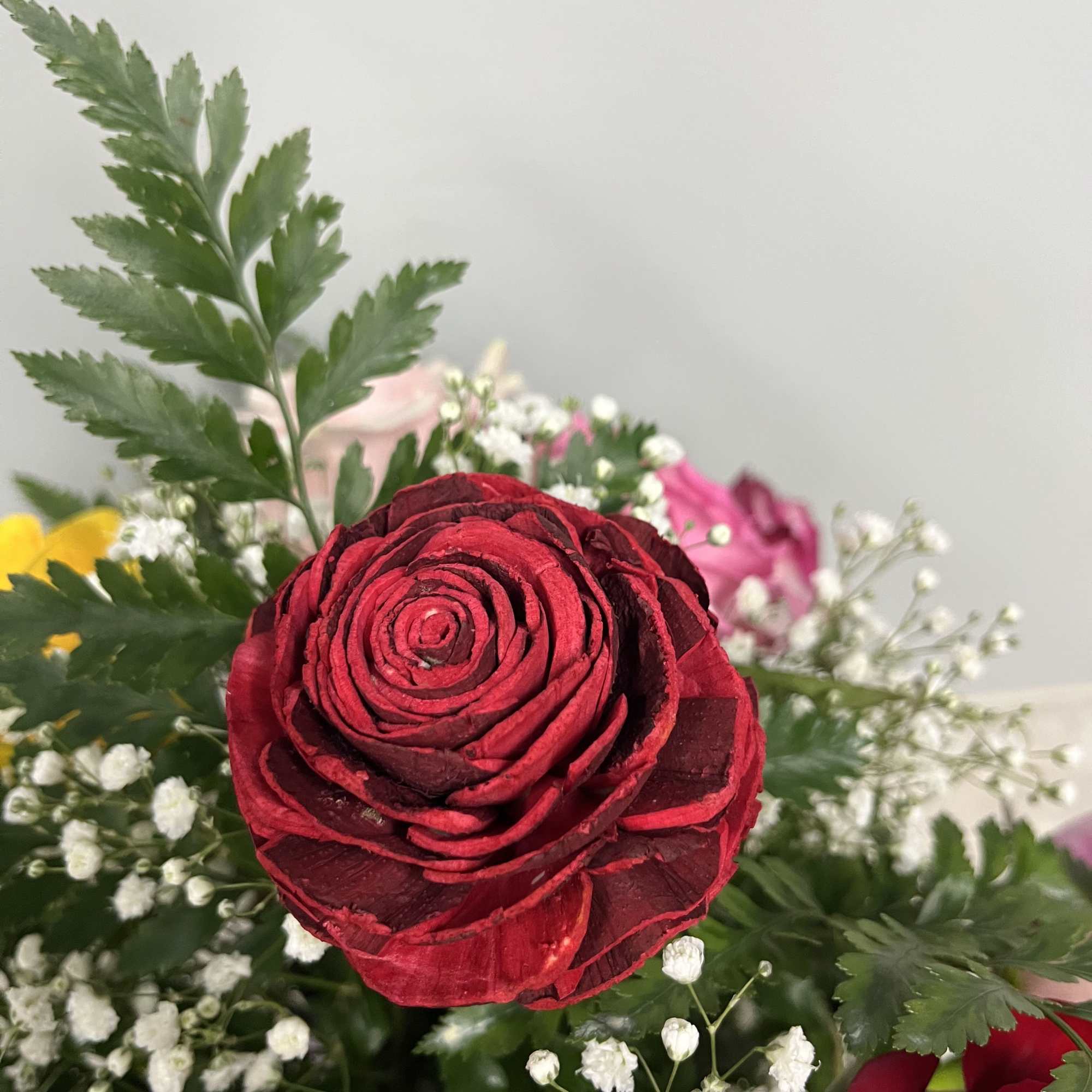 Eleven assorted colored roses with one wooden rose keepsake
all around arrangment 
approx