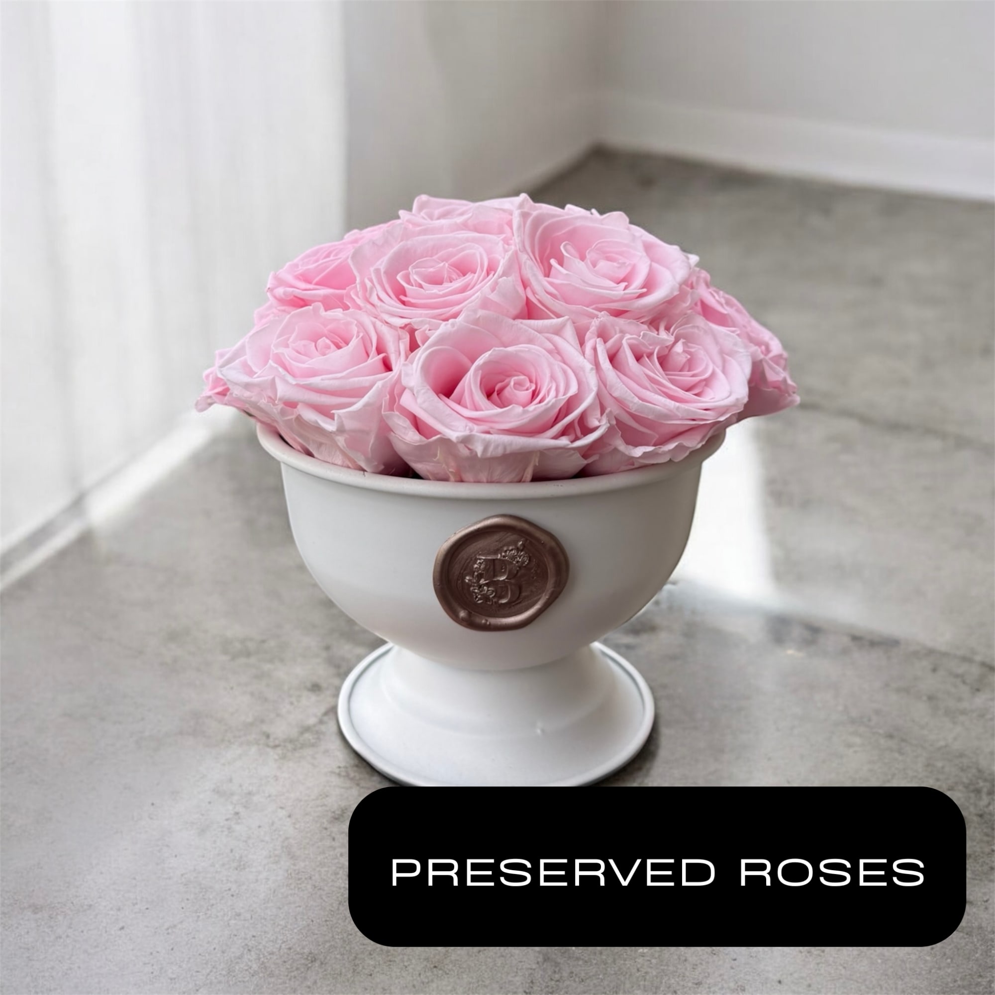 A beautiful white compote filled with 15&ndash;17 natural preserved pink roses arranged