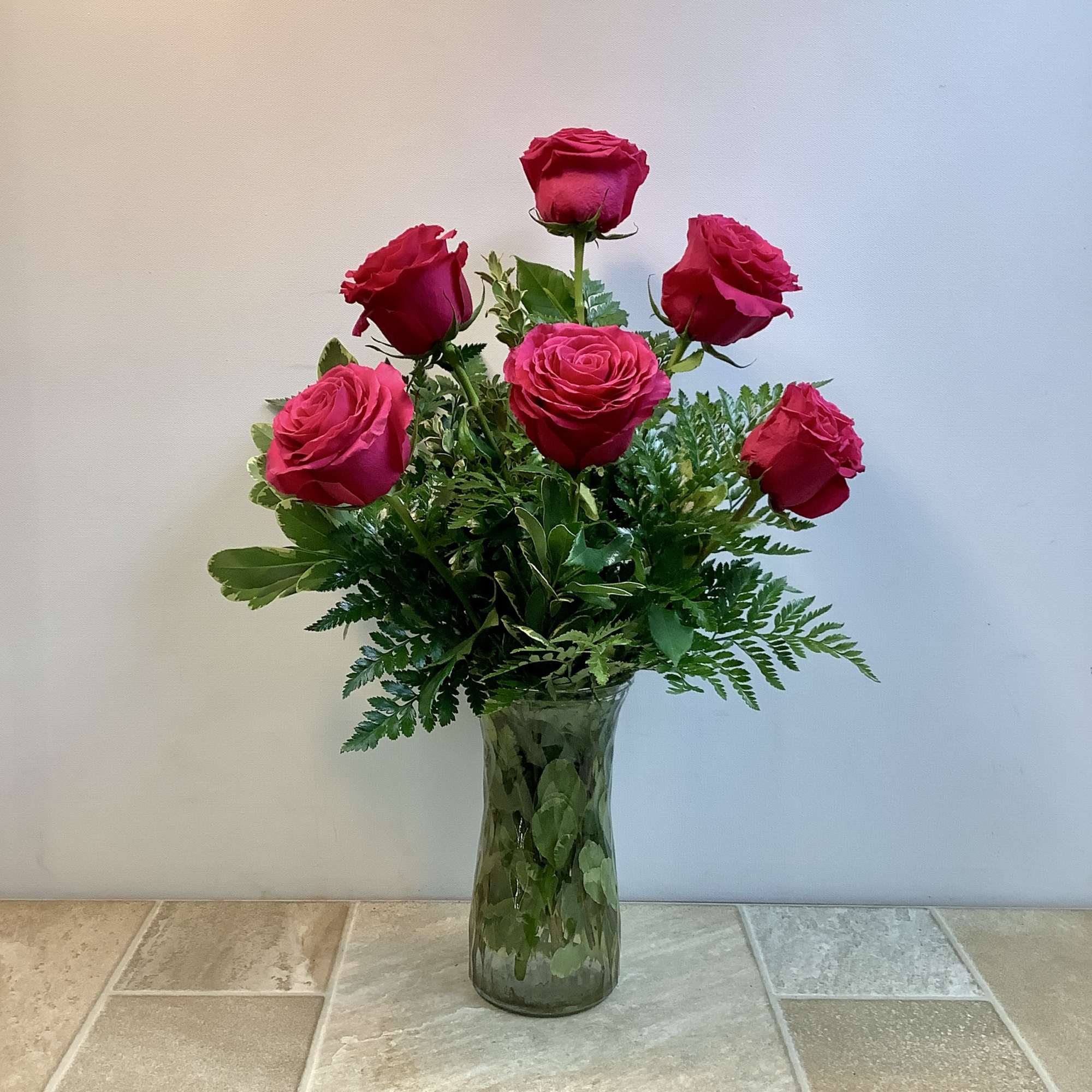 This classic bouquet features six lush pink roses arranged in a tall