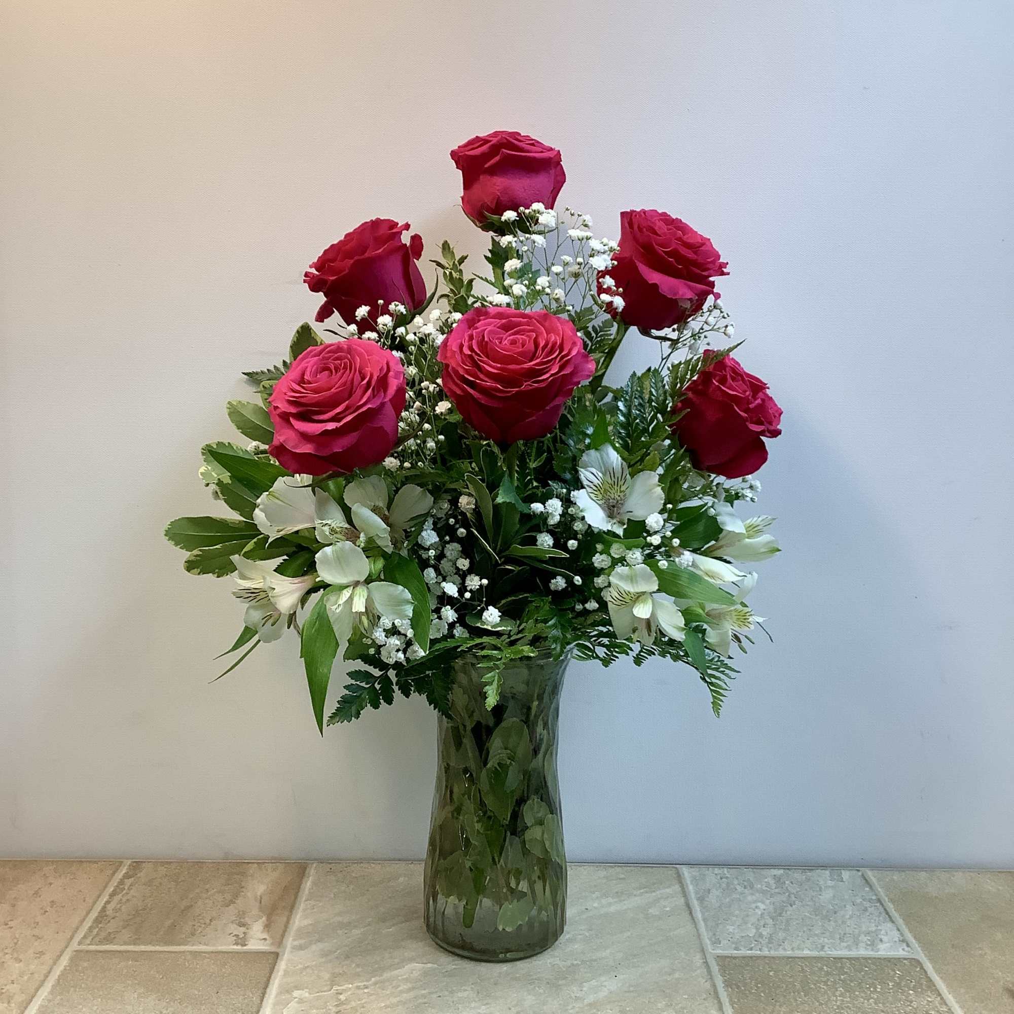 This classic bouquet features six lush pink roses arranged in a tall