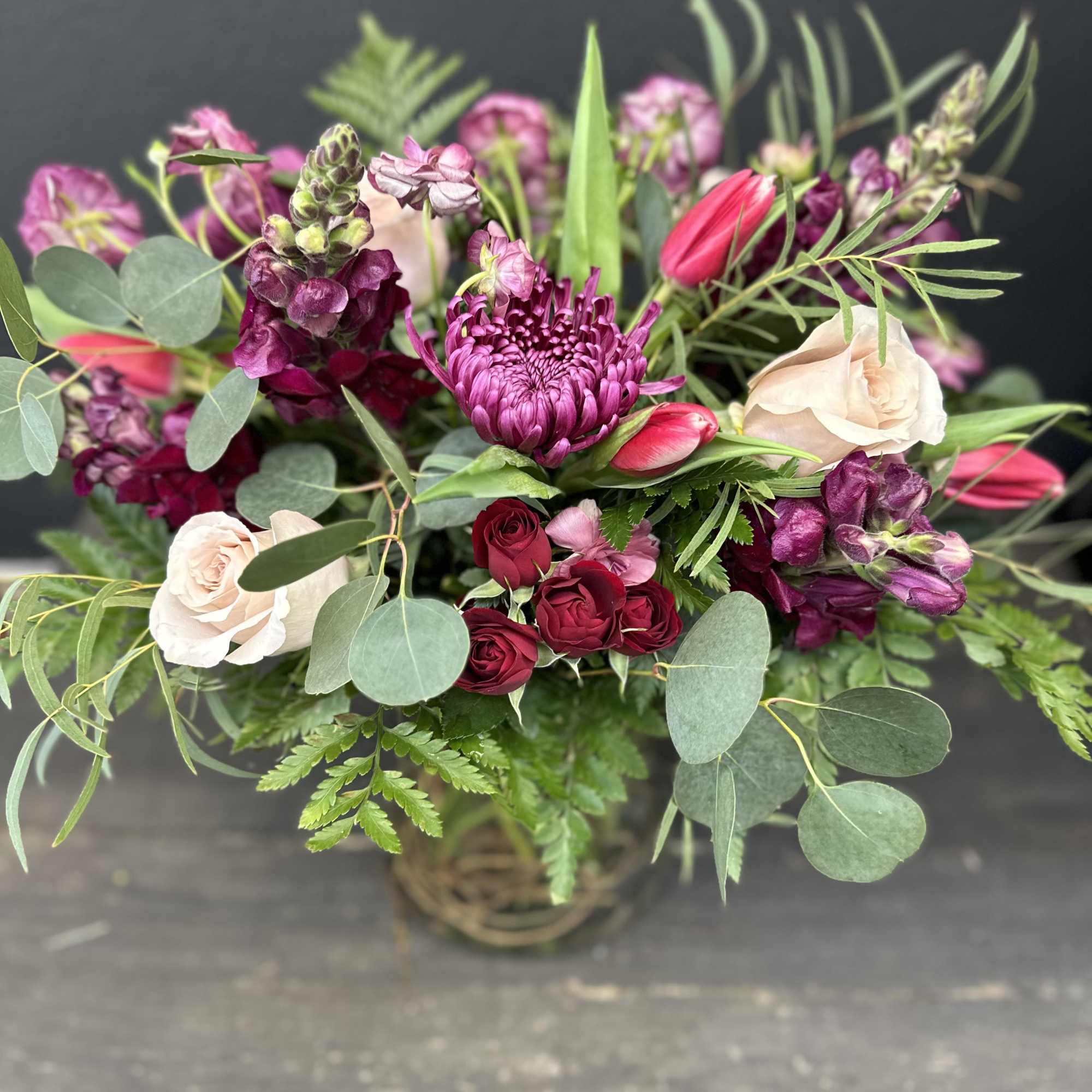 Designed using burgundy mums, maroon snapdragons, dark red spray roses, blush roses