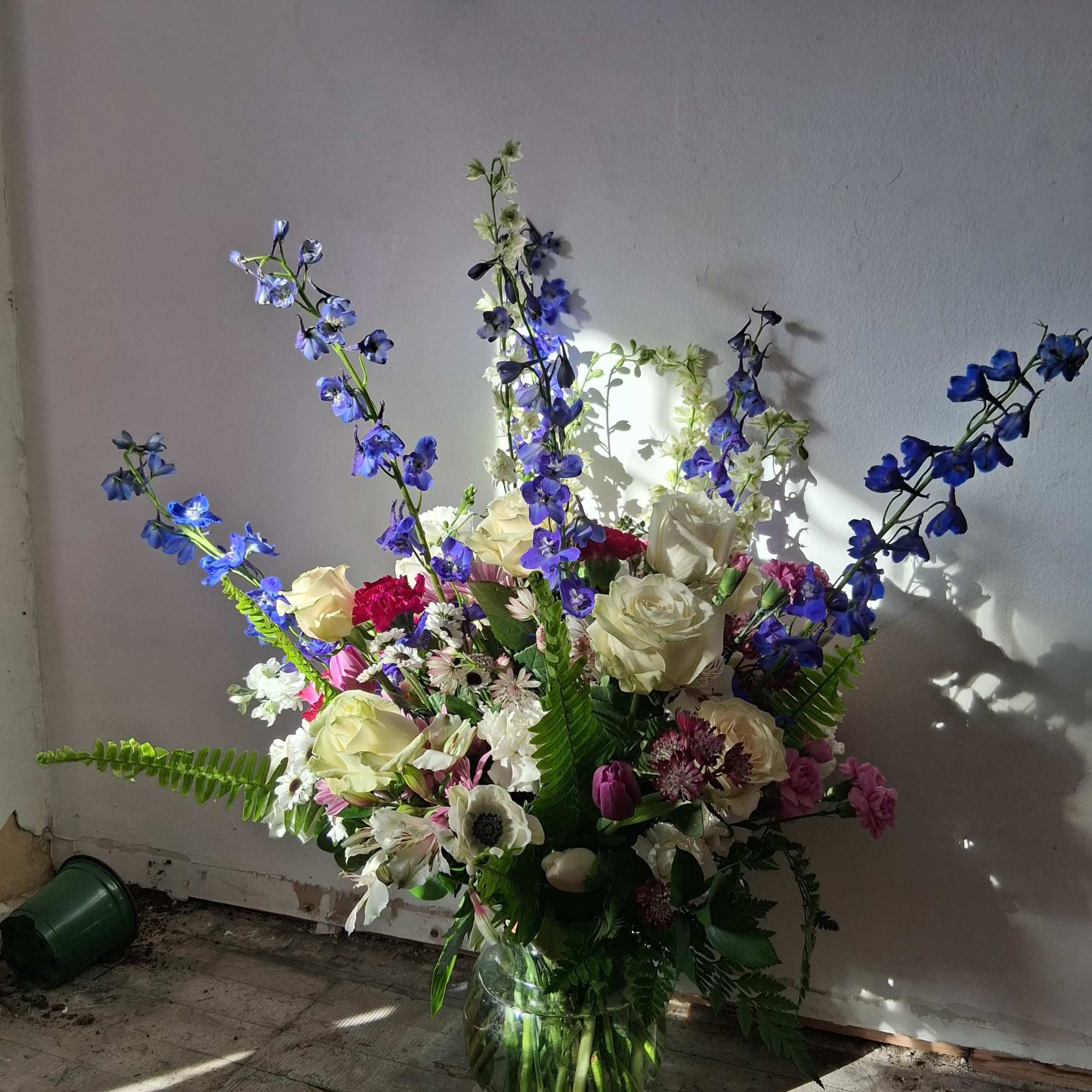 Beautiful charming crispy white roses, carnations and daisies, navy blue delphinium, burgundy
