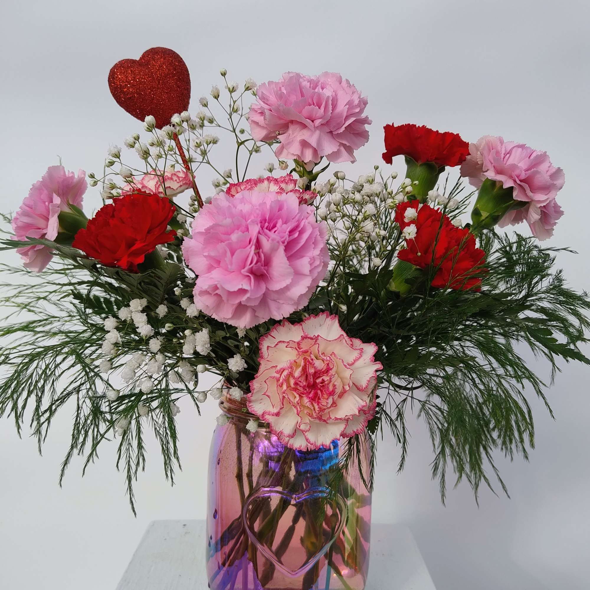 This keepsake iridescent pink mason jar with an embossed heart is filled