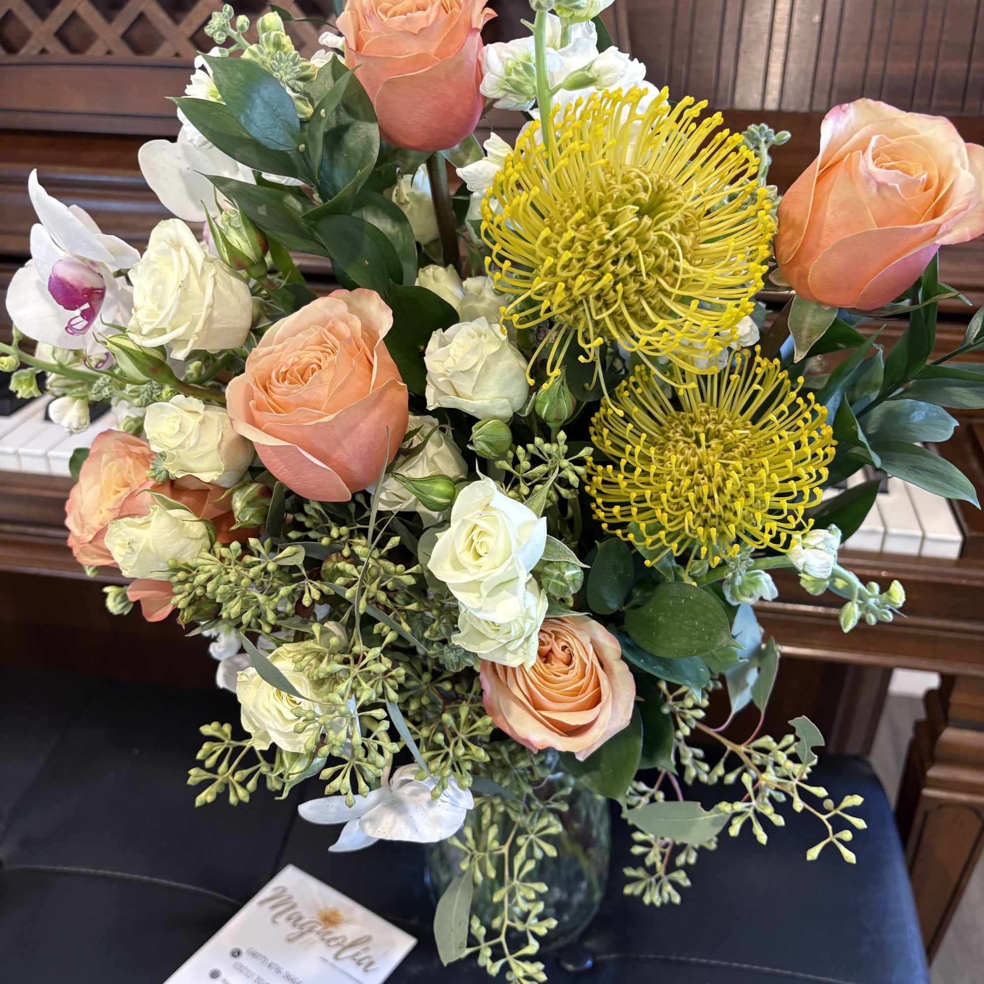 This exquisite floral arrangement showcases peach and creamy white roses paired elegantly