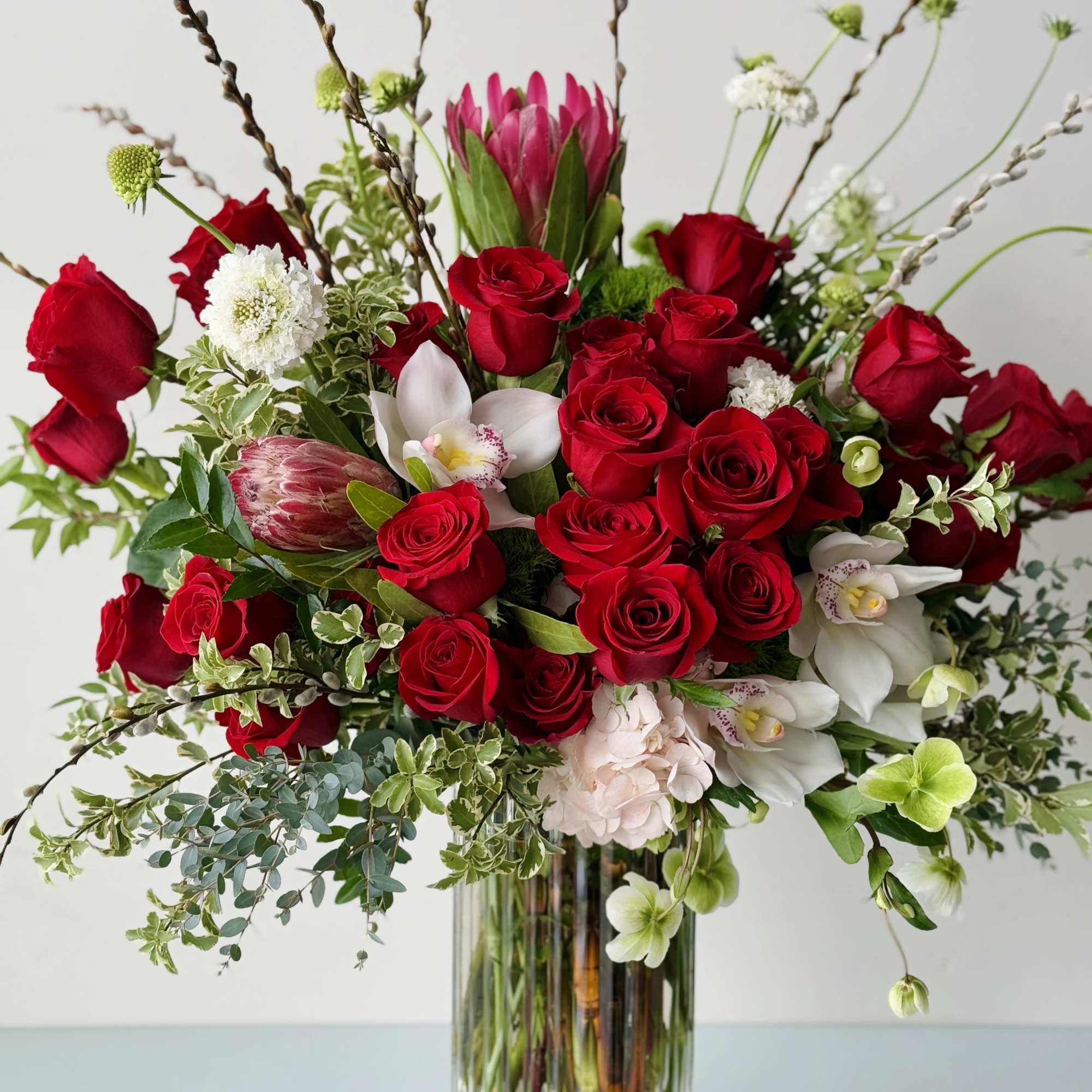 Beautiful one-sided flower arrangement with red mix blooms. This arrangement is built