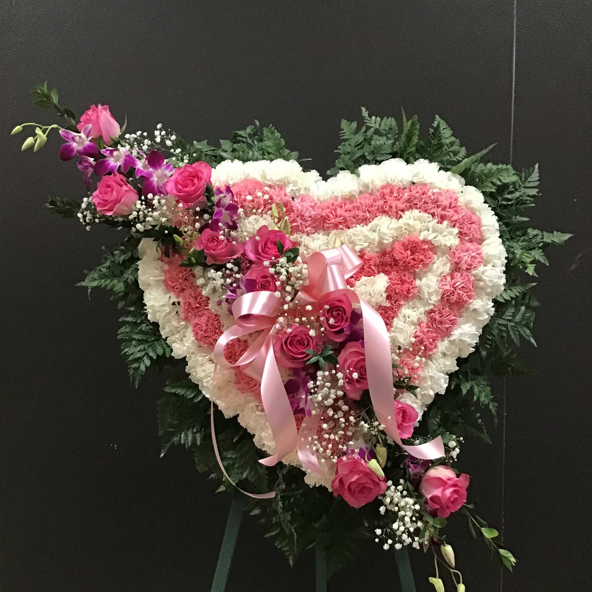 This arrangement make with pink and white carnations and lavender roses 