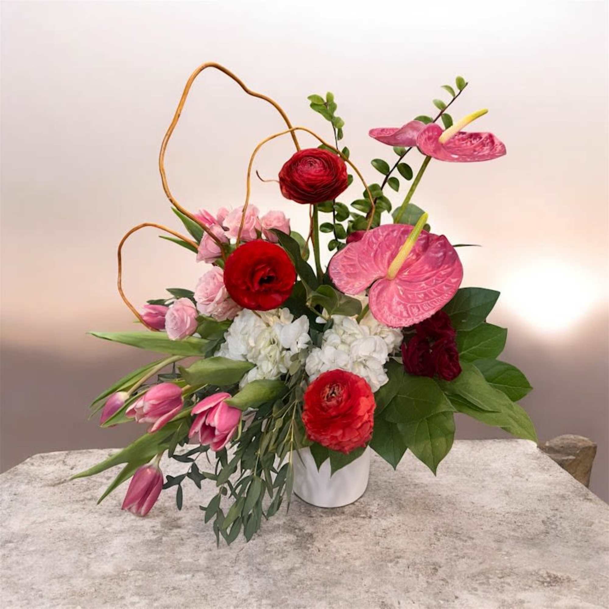 Anthurium, Roses, Hydrangea and Ranunculus with greeneries in a vase