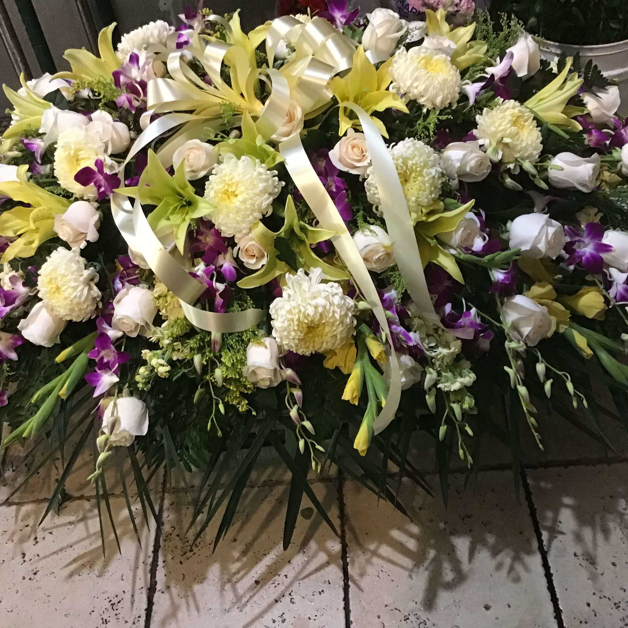 This casket spray make with purple dendrobium orchids and yellow wind lily