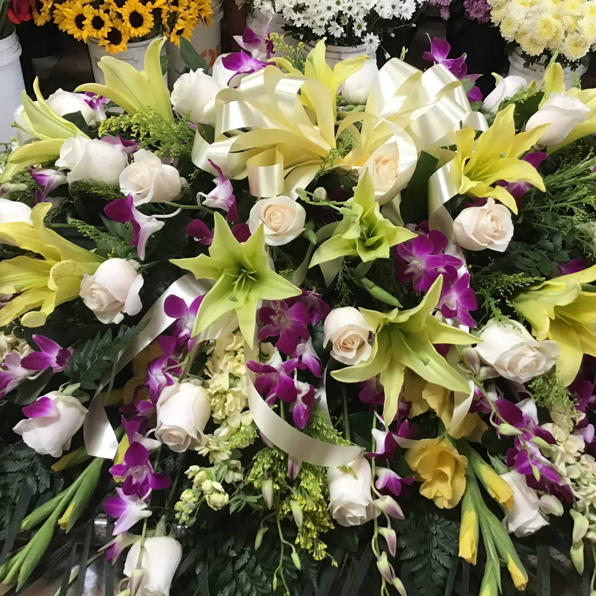 This casket spray make with purple dendrobium orchids and yellow wind lily