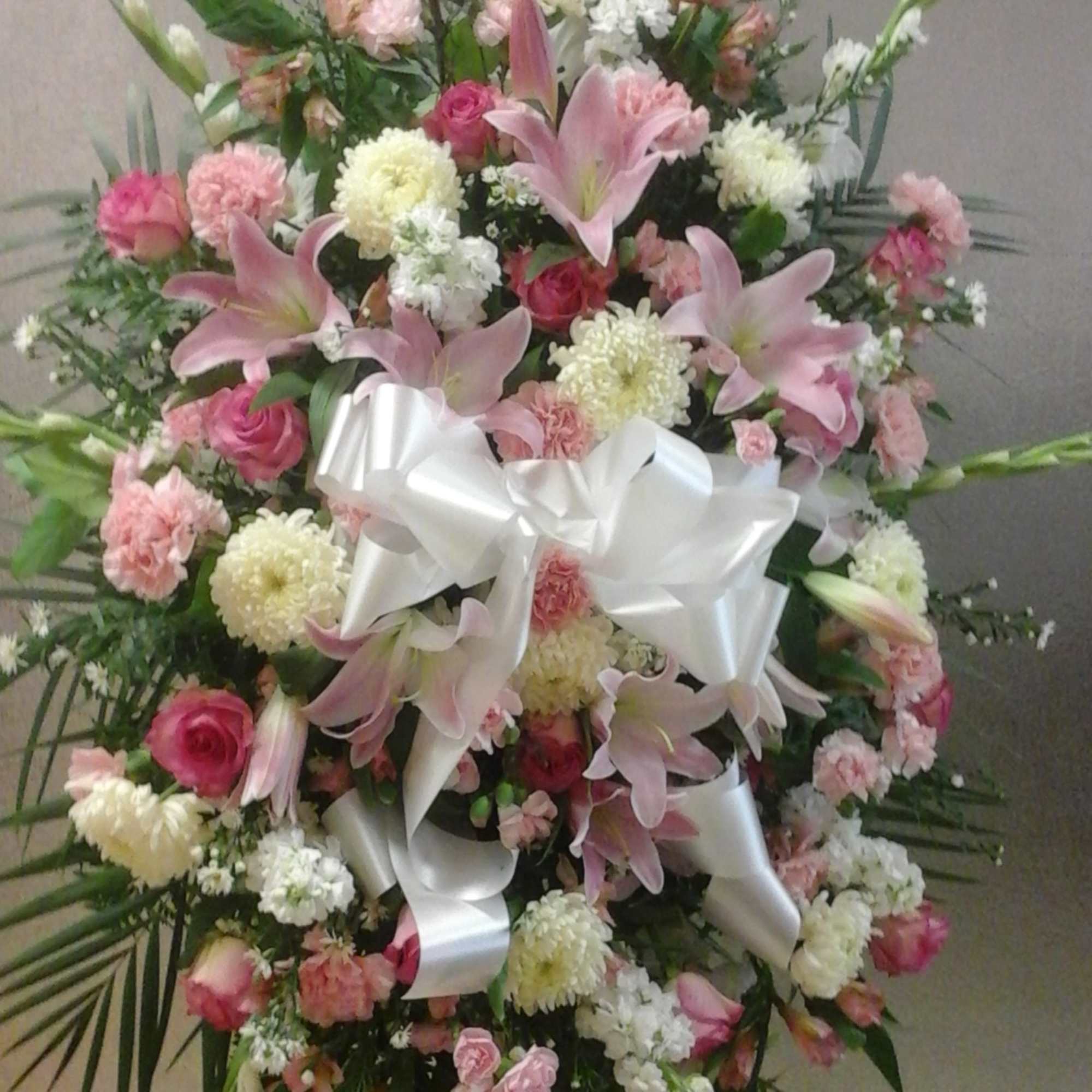 This standing spray make with pink and white colors flower , roses