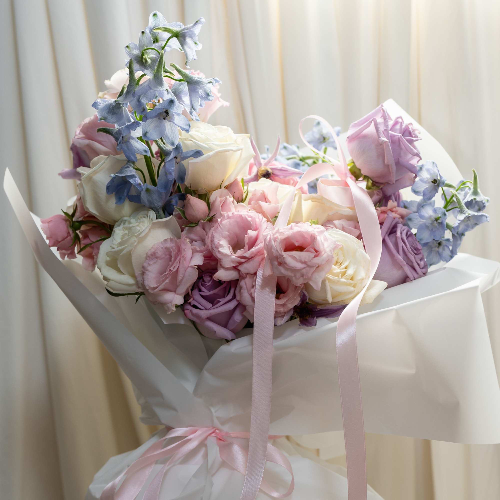A Large bouquet with pink, white, lavendar and blue flowers. This bouquet