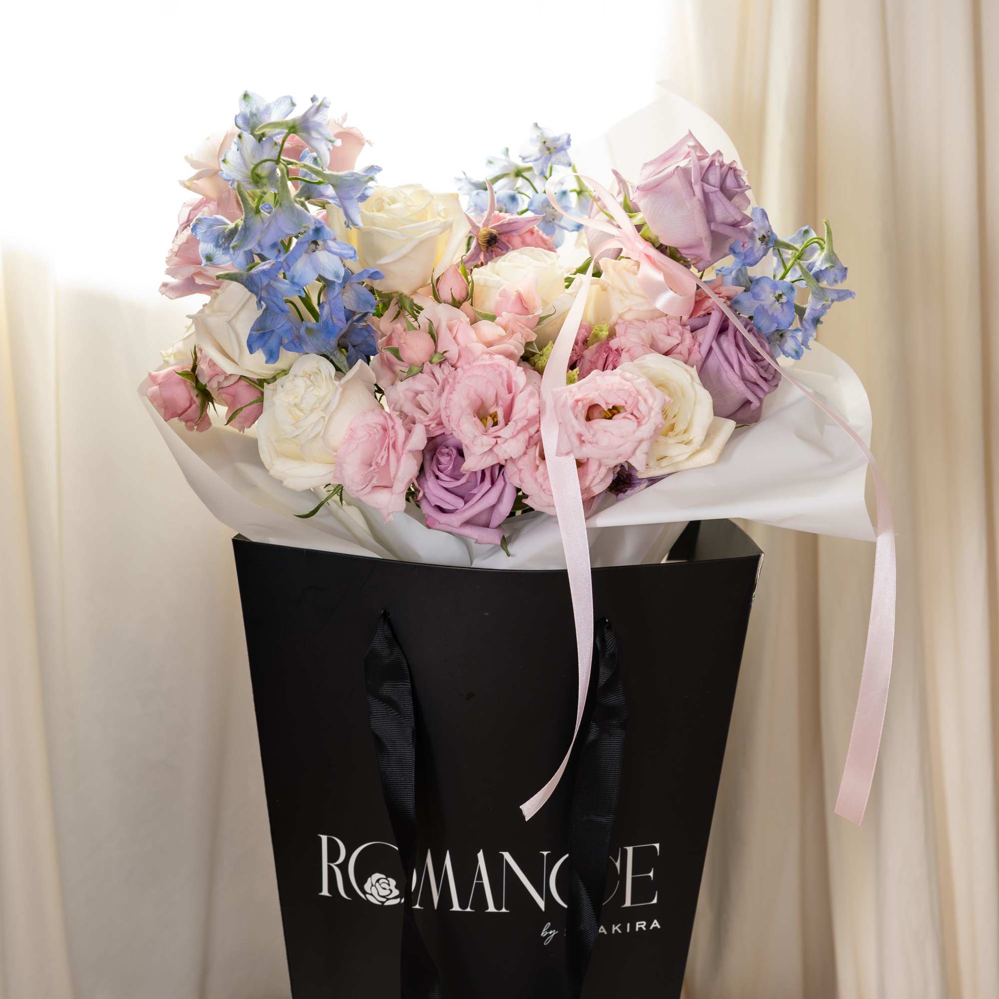 A Large bouquet with pink, white, lavendar and blue flowers. This bouquet