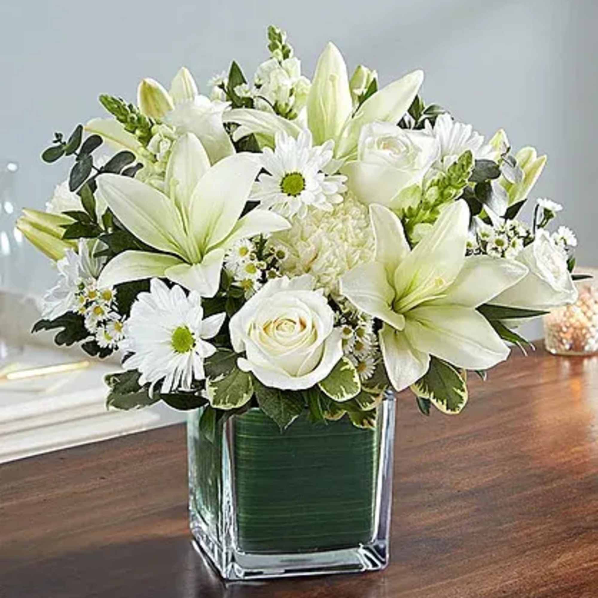 Arrangement of white roses, Asiatic lilies, football mums, snapdragon, daisy poms and
