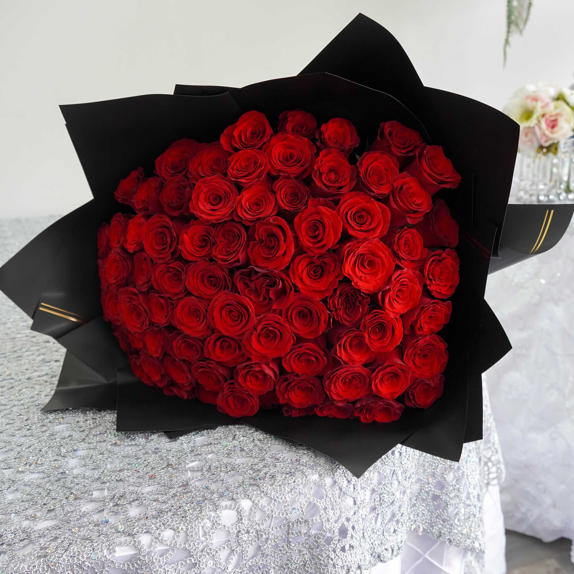 A stunning hand tied bouquet of premium red roses wrapped in sleek