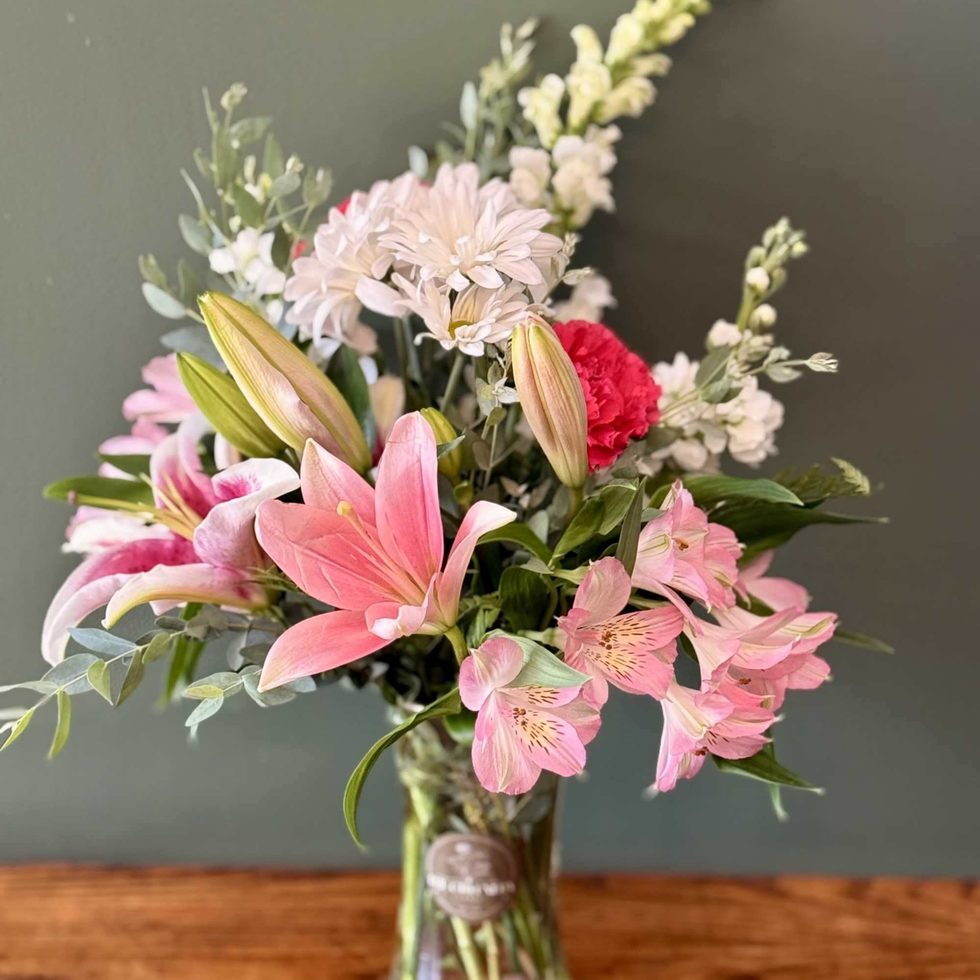 Lilies, alstromerias and daisies in a vase arrangement
As a local florist in