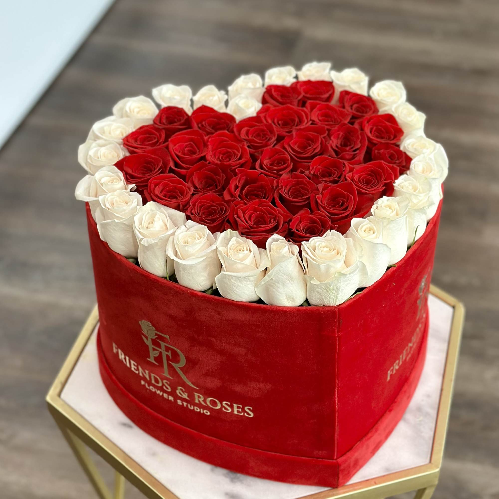 A stunning heart design made of fresh red and white roses in