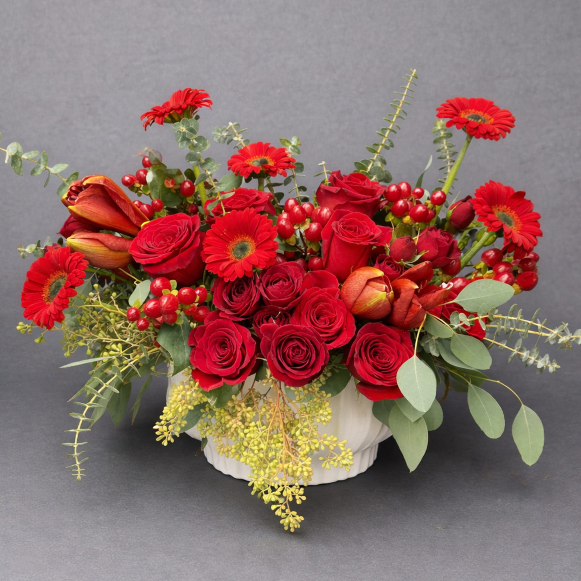 An intense and romantic design of premium red blooms accented with lush