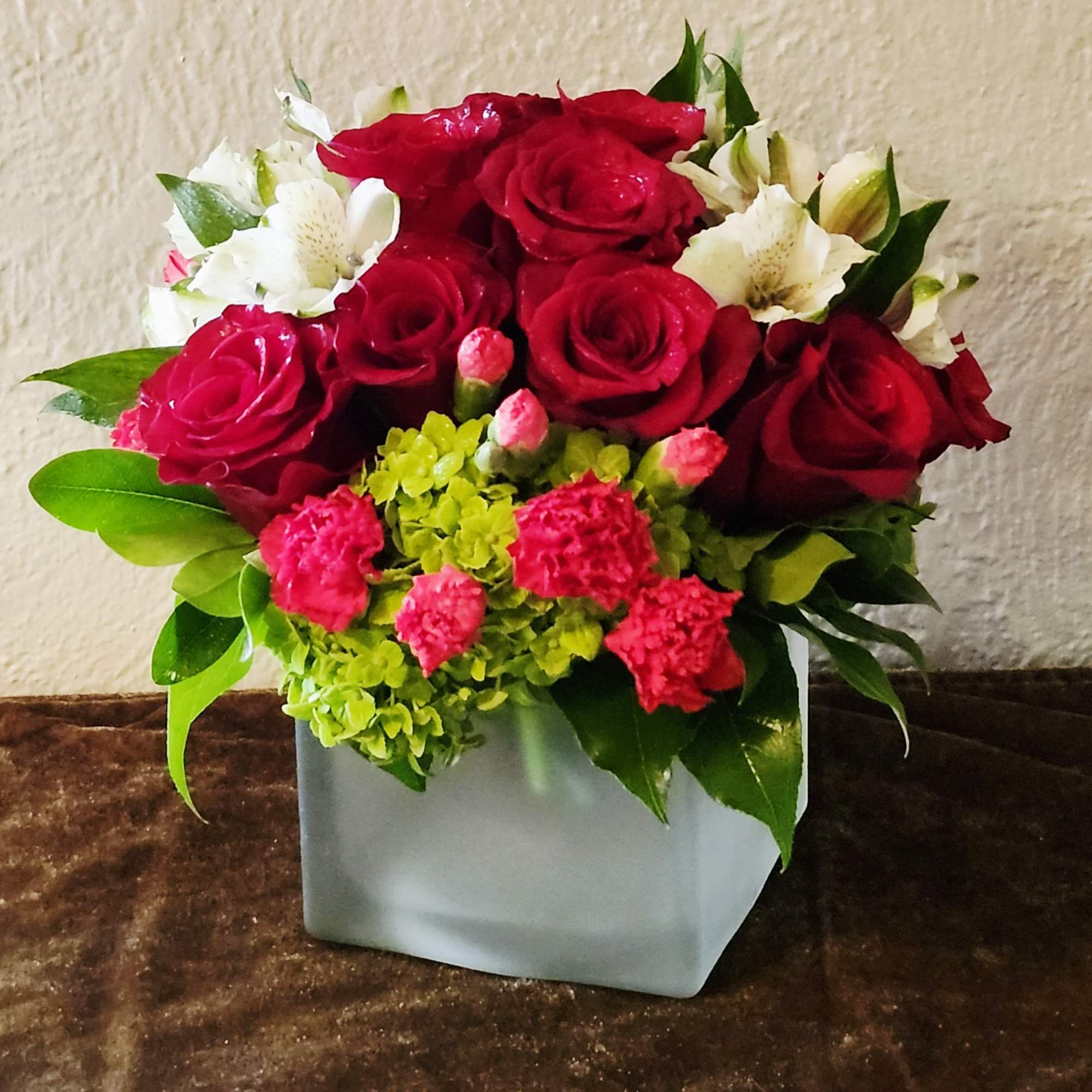 A stunning blend of deep red roses kissed with soft white accents