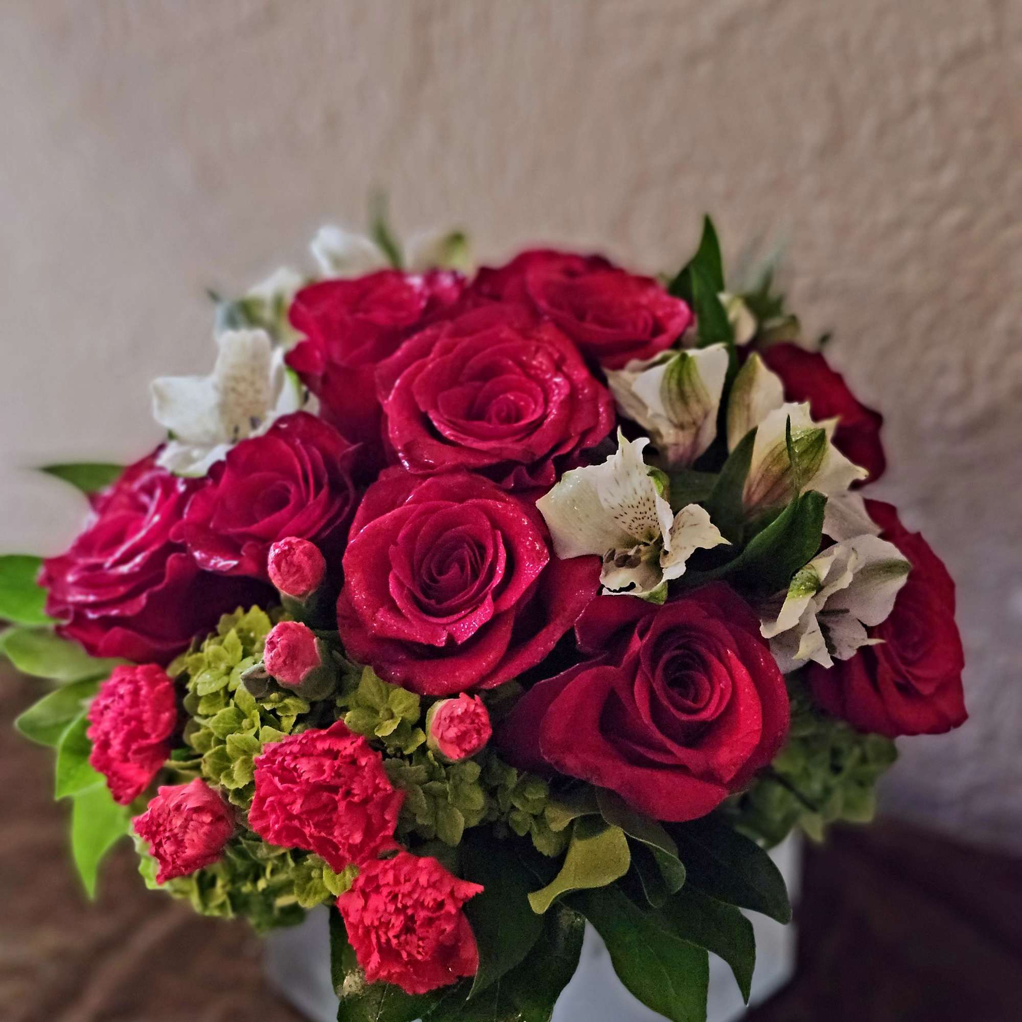 A stunning blend of deep red roses kissed with soft white accents