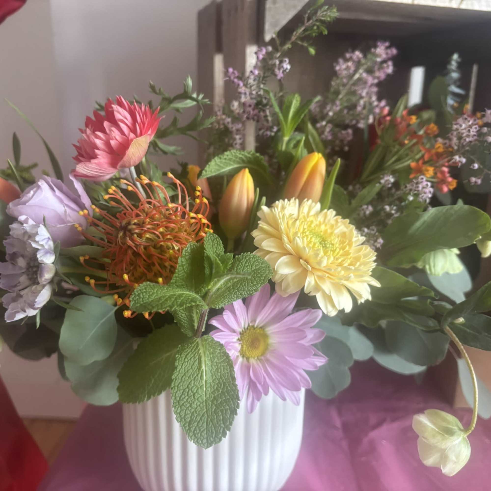 An arrangement that is filled with delight, colorful local tulips and anemones