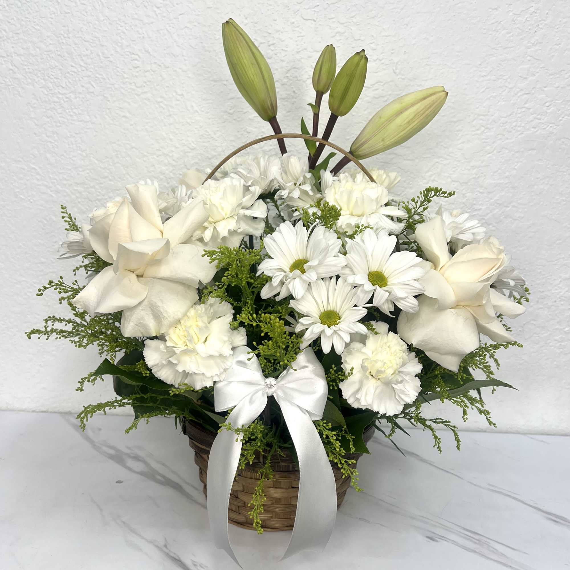 Buyer will receive a Basket with white roses, Lilly, carnations, and daisies.