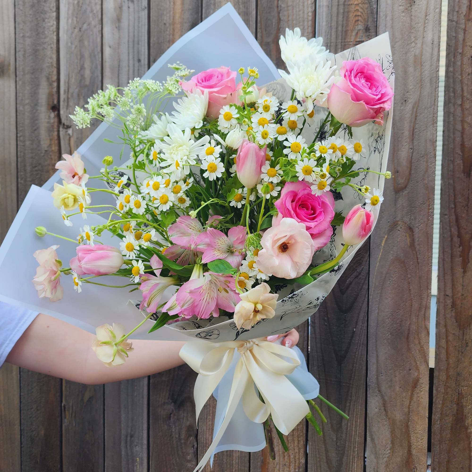 This is a Hand Wrapped Bouquet in Spring Colors with some roses