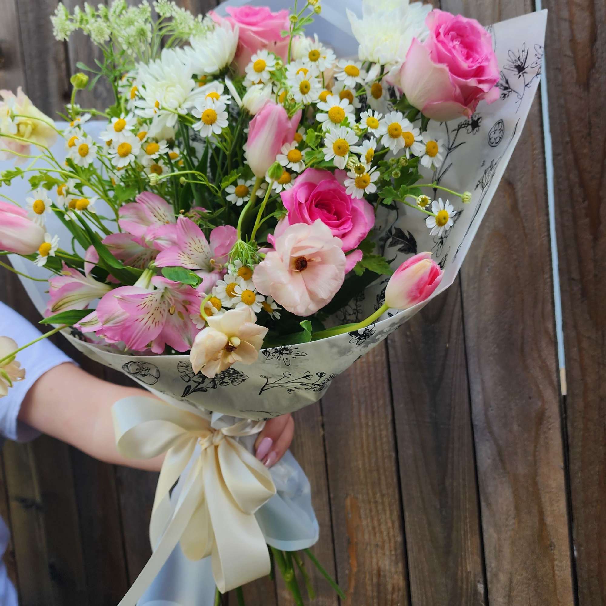 This is a Hand Wrapped Bouquet in Spring Colors with some roses